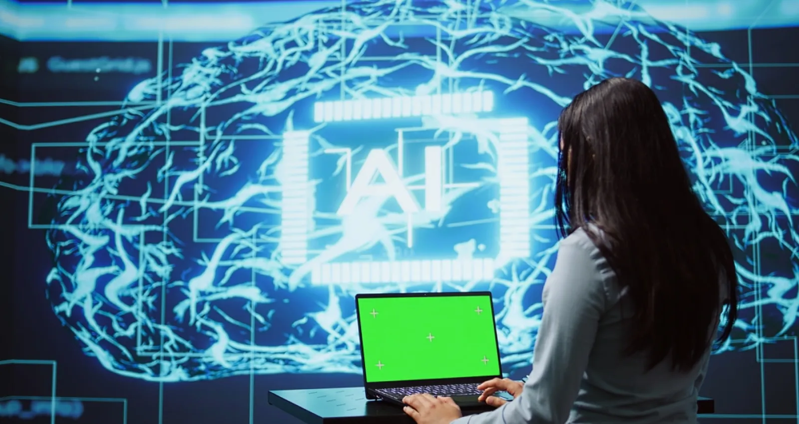 Foto de una mujer sentada frente a una pantalla que dice IA. Foto de Schneider Electric