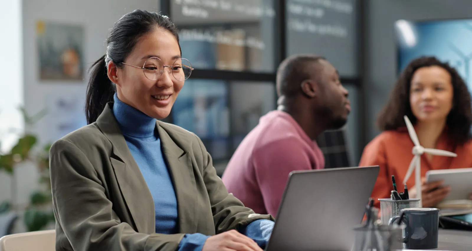 Foto de una mujer sonriendo frente a un computador