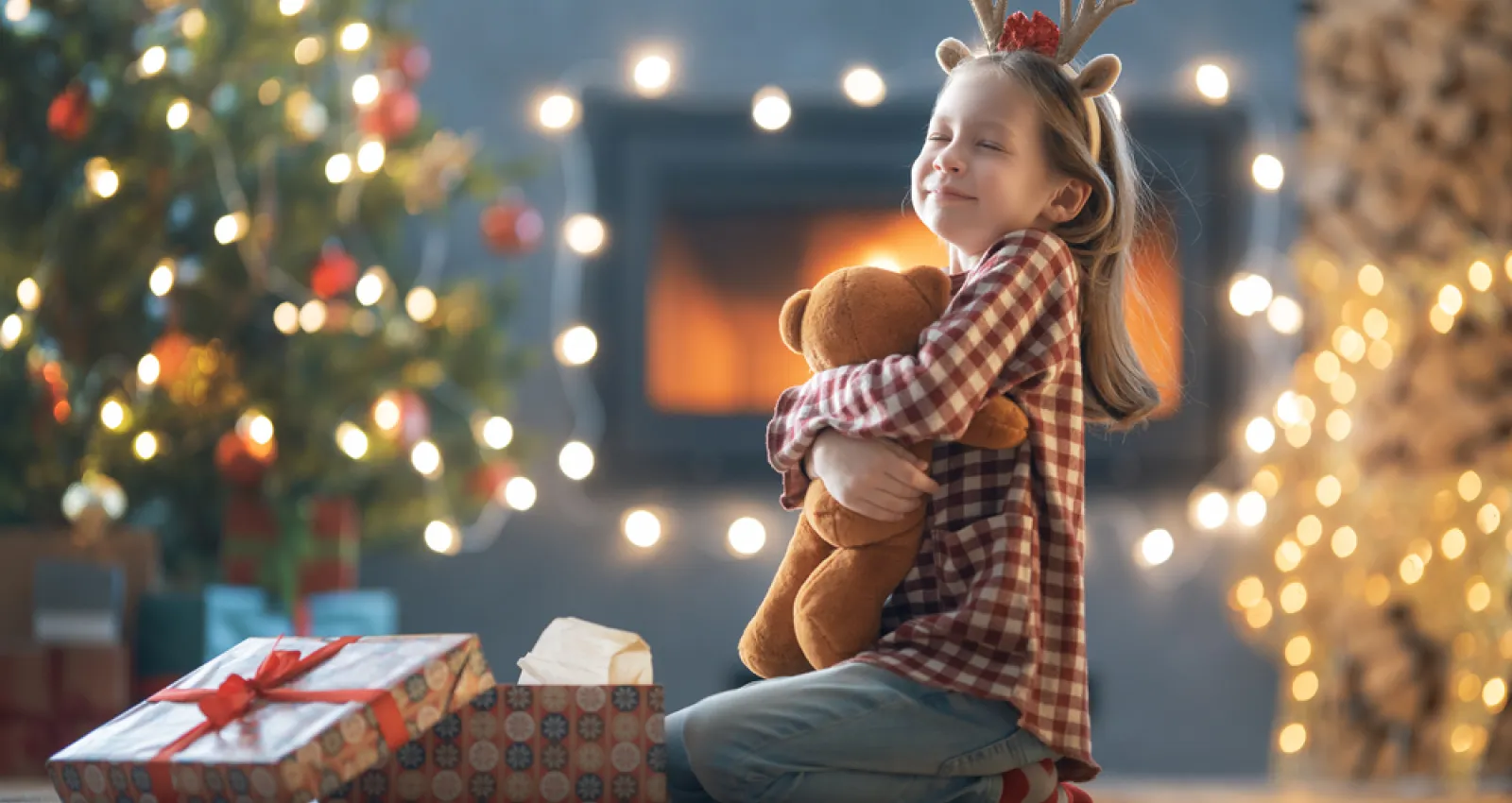 Foto de una niña con un regalo de navidad en sus brazos