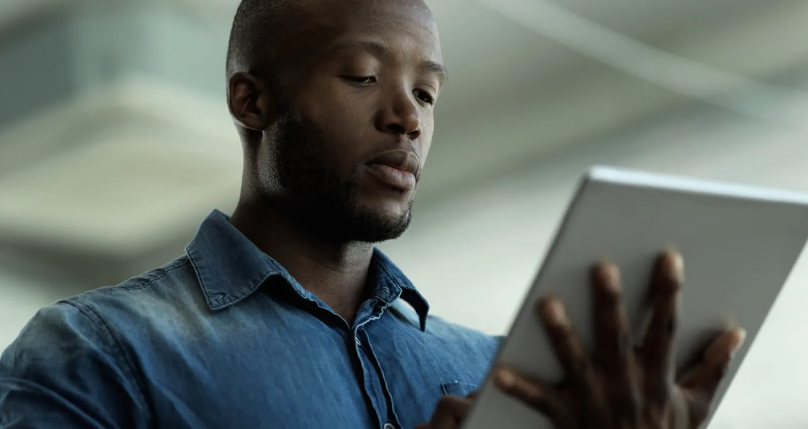 Foto de una persona afro con una tablet en la mano