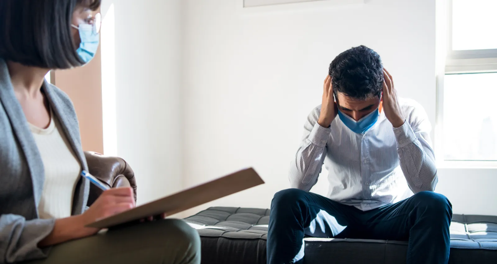 Foto de una persona agarrandose la cabeza en un consultorio