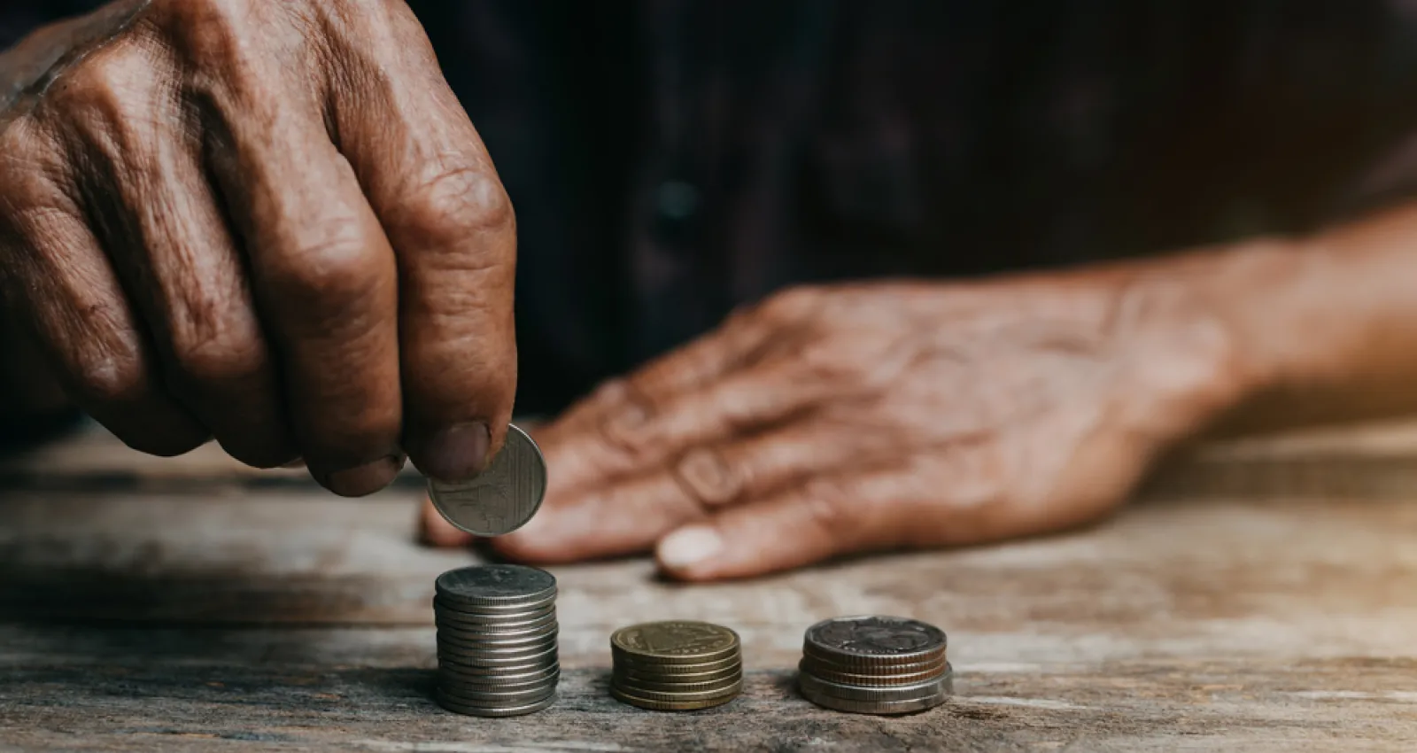 Foto de una persona apilando monedas sobre una mesa