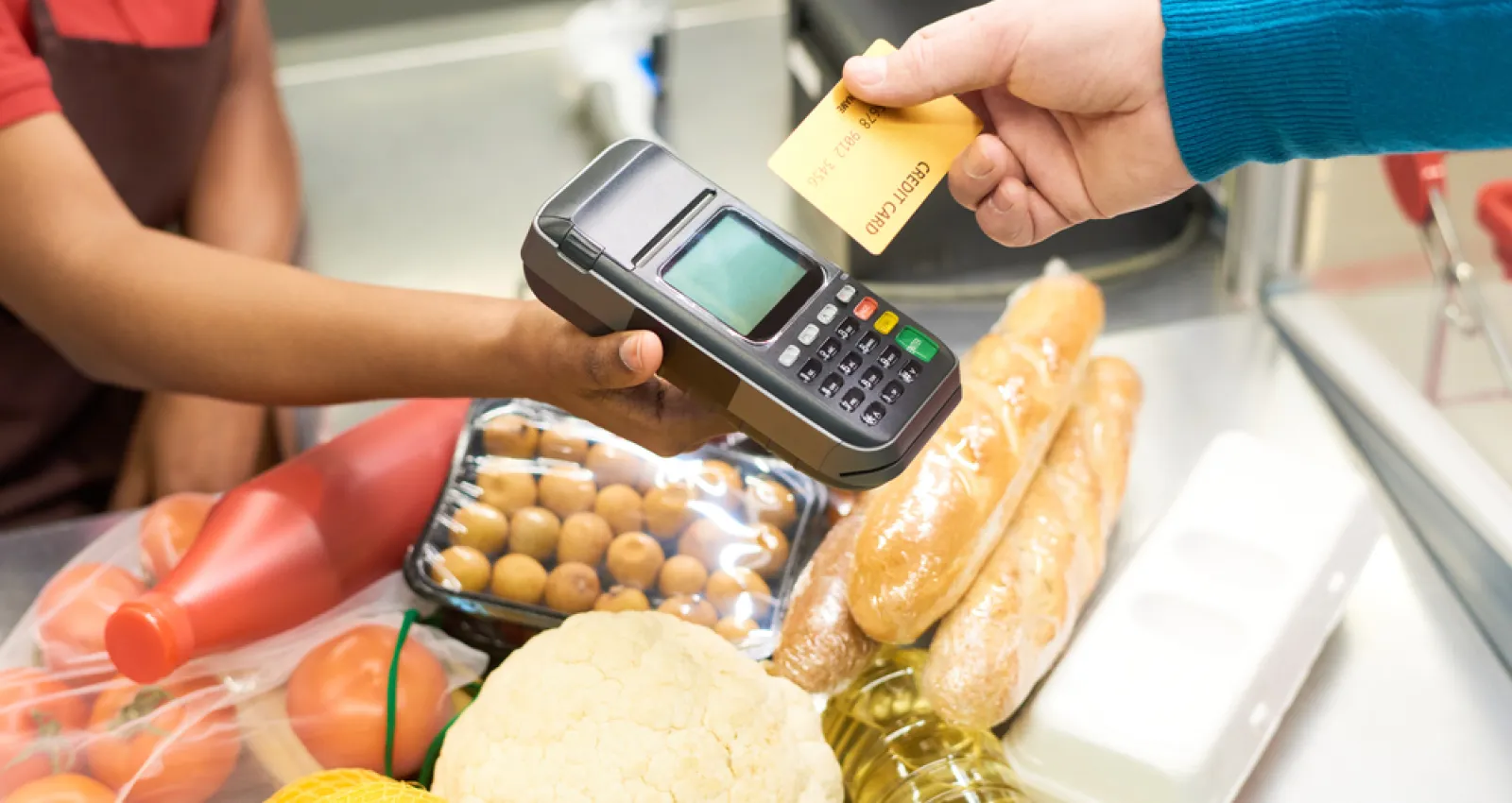 Foto de una persona comprando con una tarjeta mediante un datafono