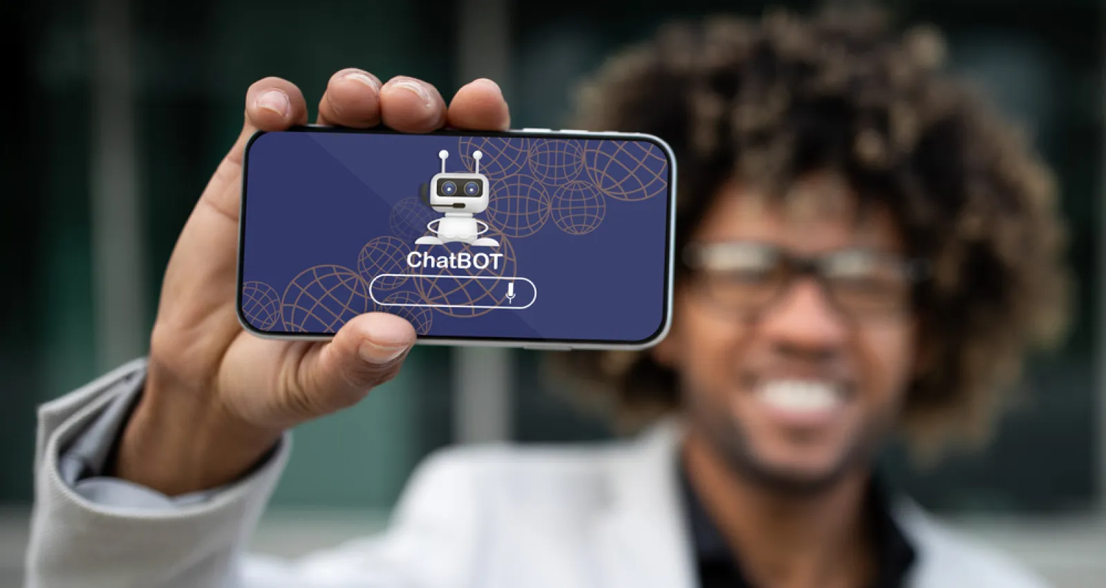 Foto de una persona con un celular en la mano que dice chatbot