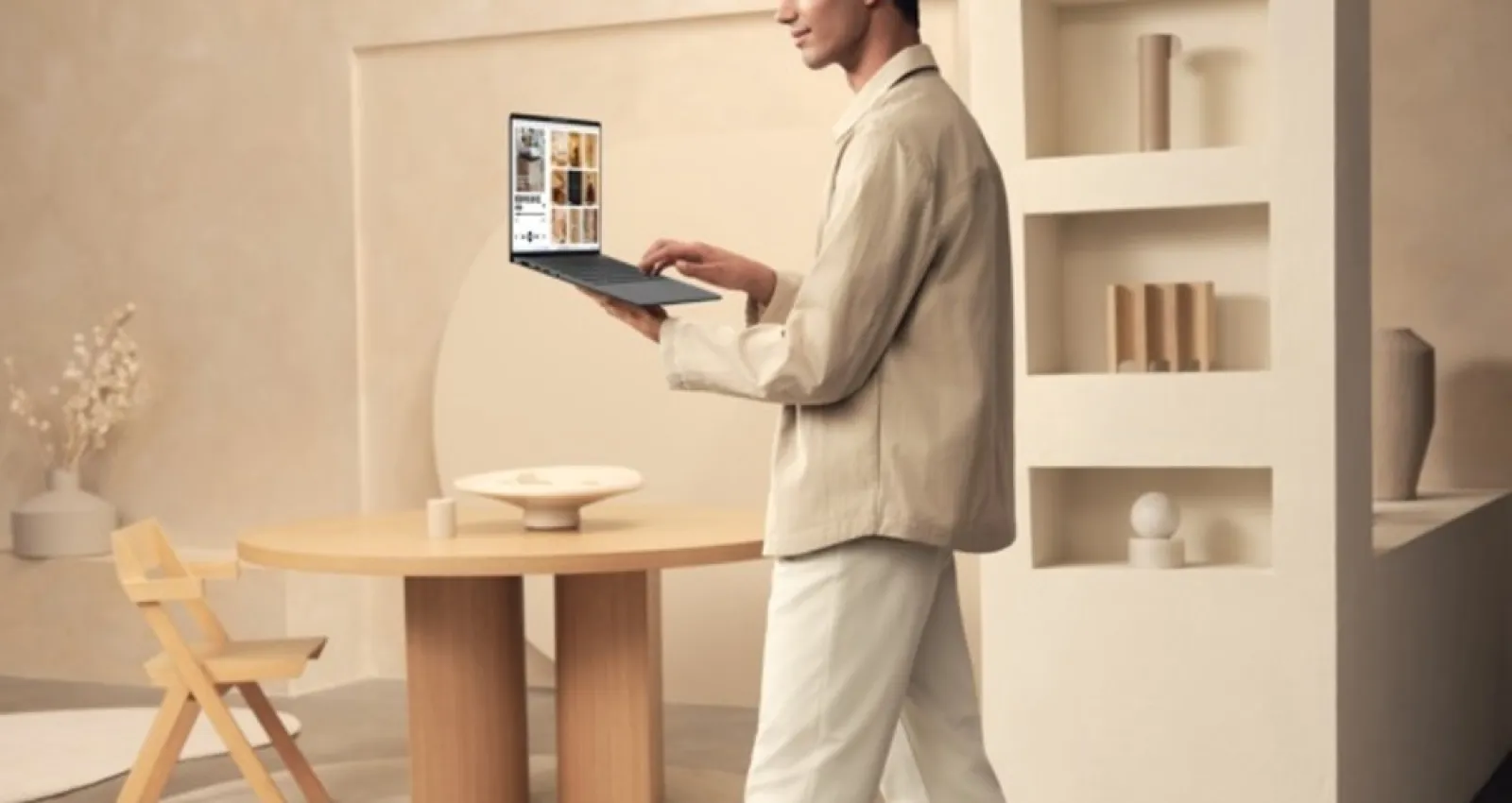 Foto de una persona con un computador en la mano caminando por una sala