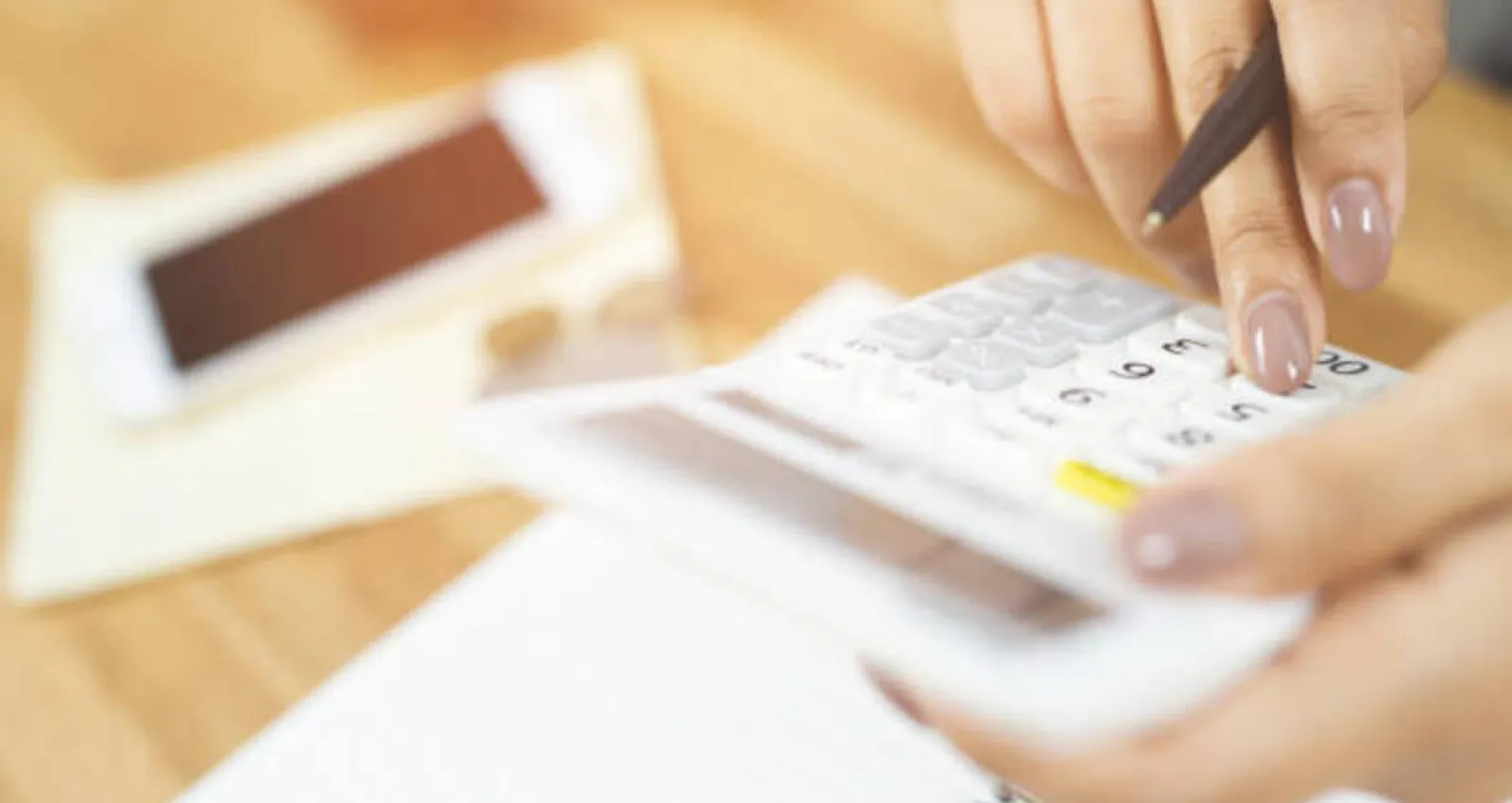 Foto de una persona con una calculadora en la mano