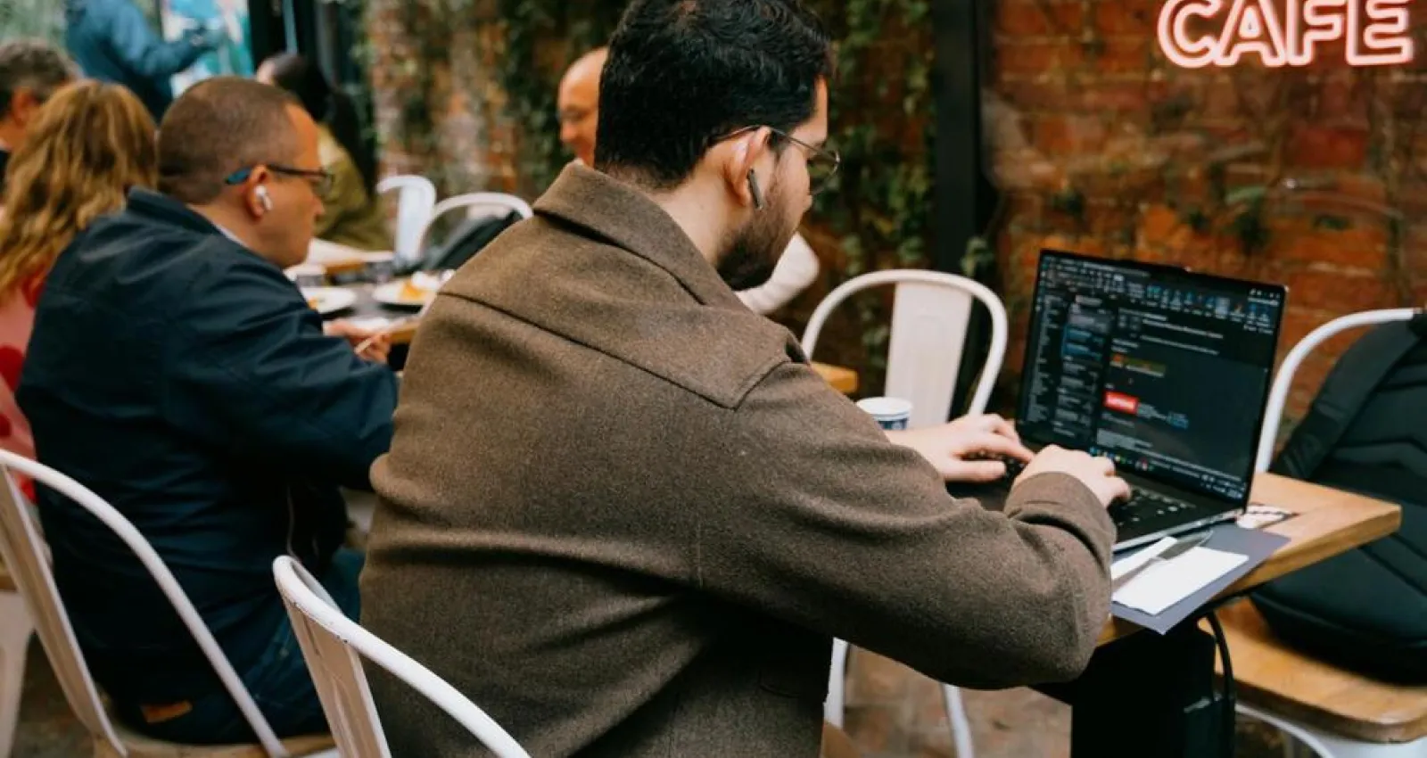 Foto de una persona de espaldas escribiendo sobre un computador