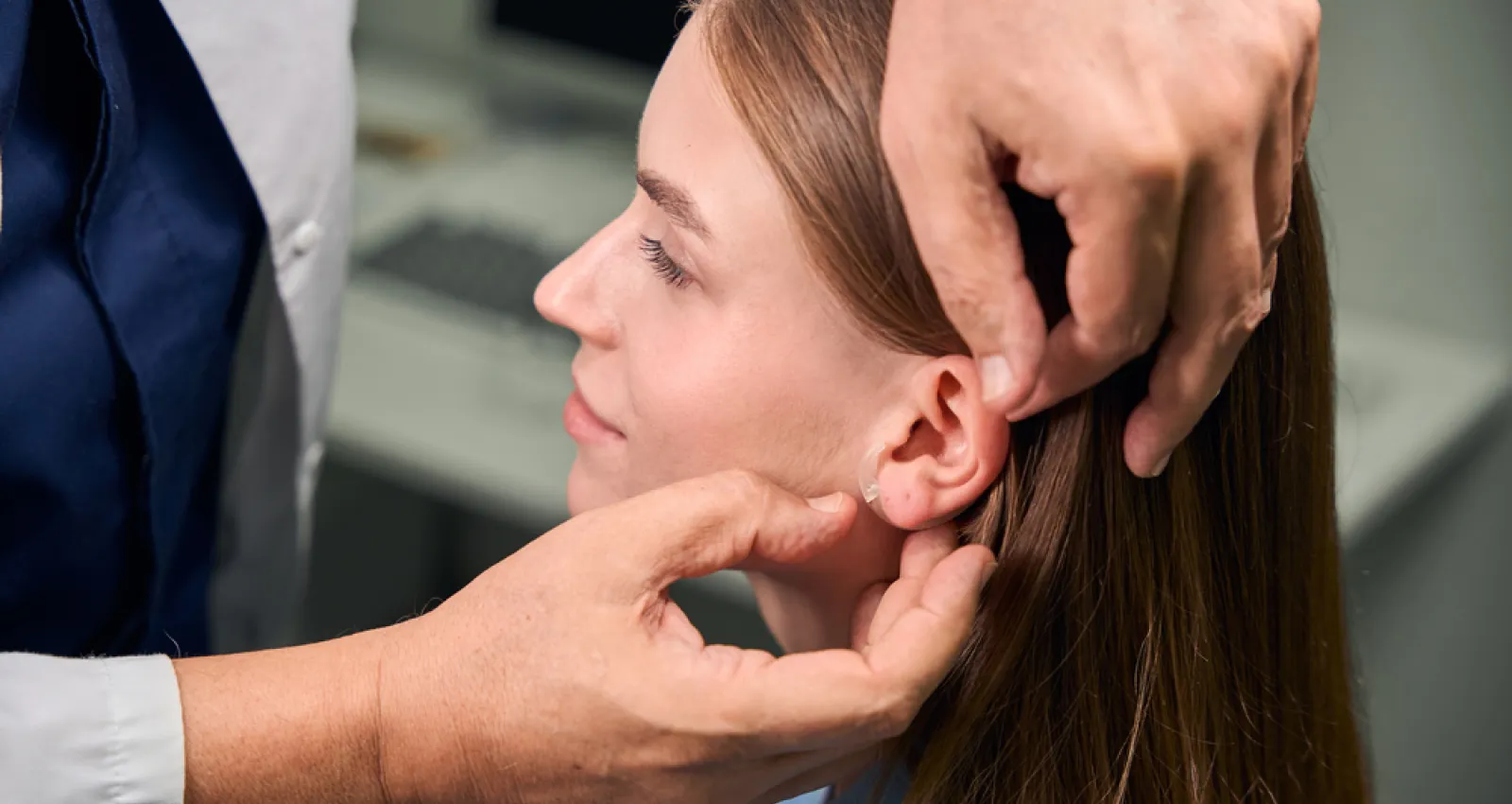 Foto de una persona revisando la oreja de una mujer