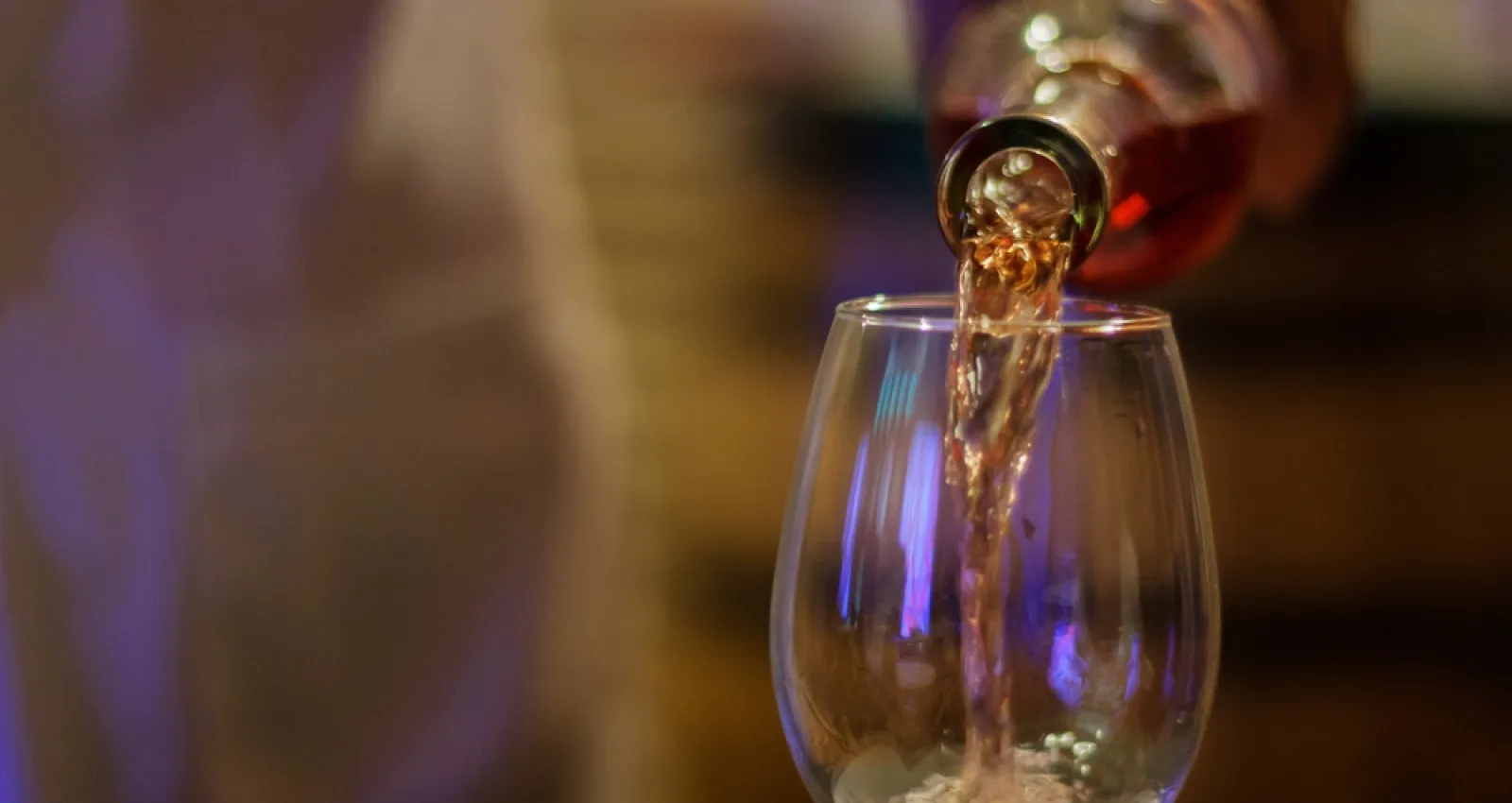 Foto de una persona sirviendo una copa de vino