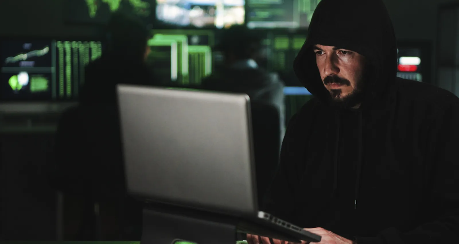 Foto de una persona trabajando con un hoodie frente a un computador