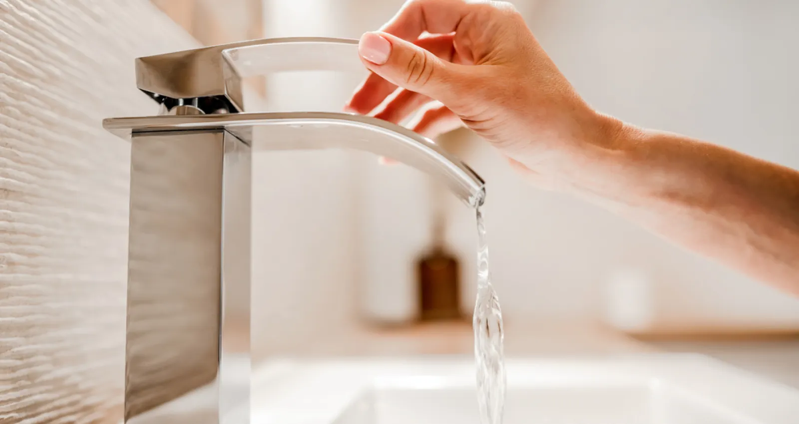 Foto de una persona utilizando un grifo de agua
