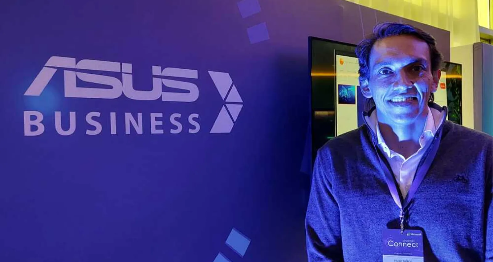 Foto de una personas mirando a la cámara, plano medio, con luz morada y de fondo dice Asus Business