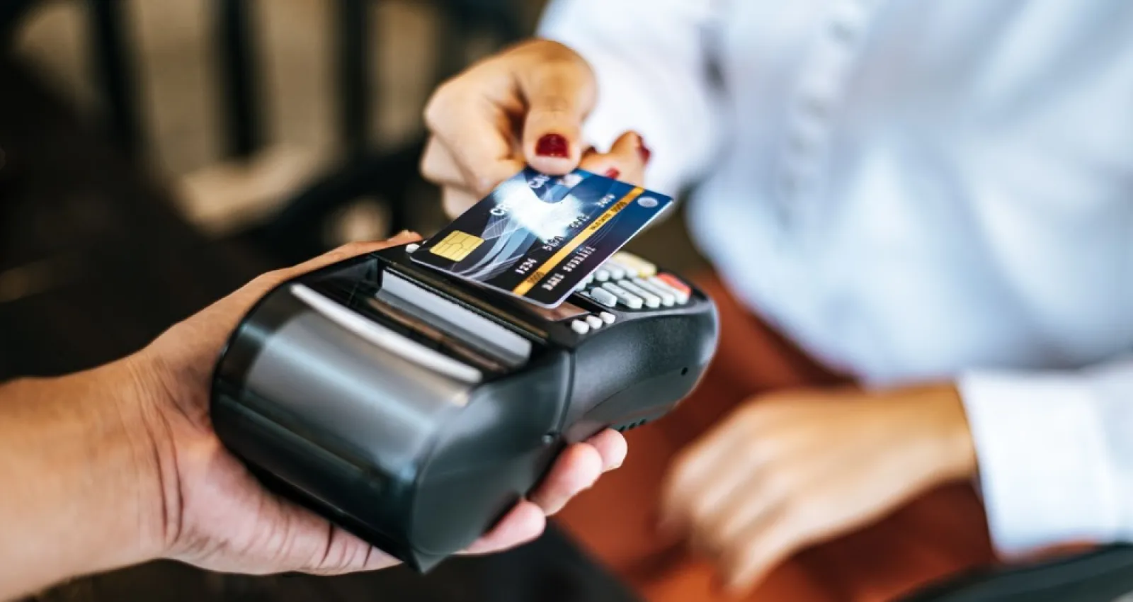 Foto de una personas sosteniendo un datáfono en sus manos