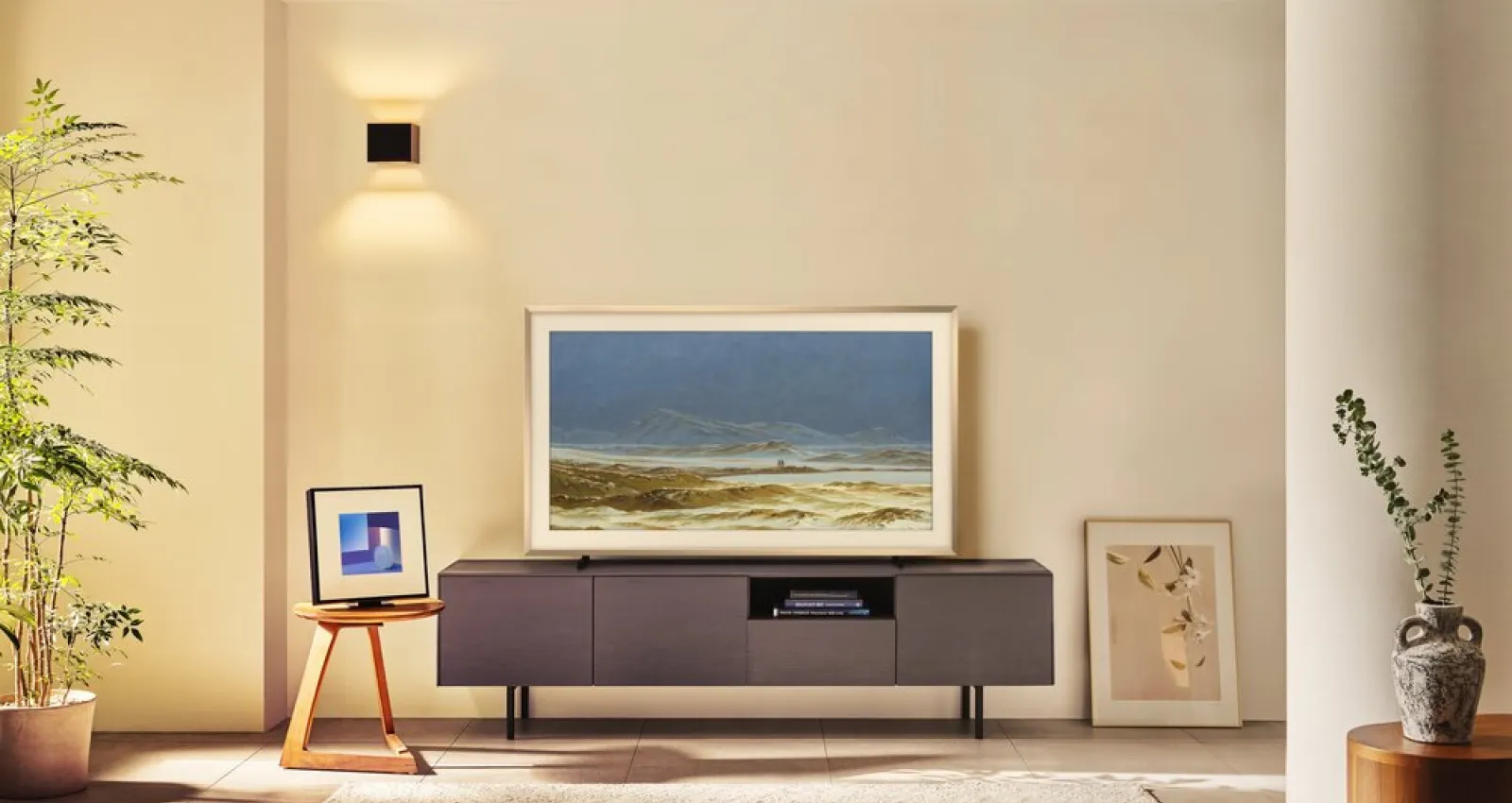 Foto de una sala con un televisor con una mesa y un fondo color pastel