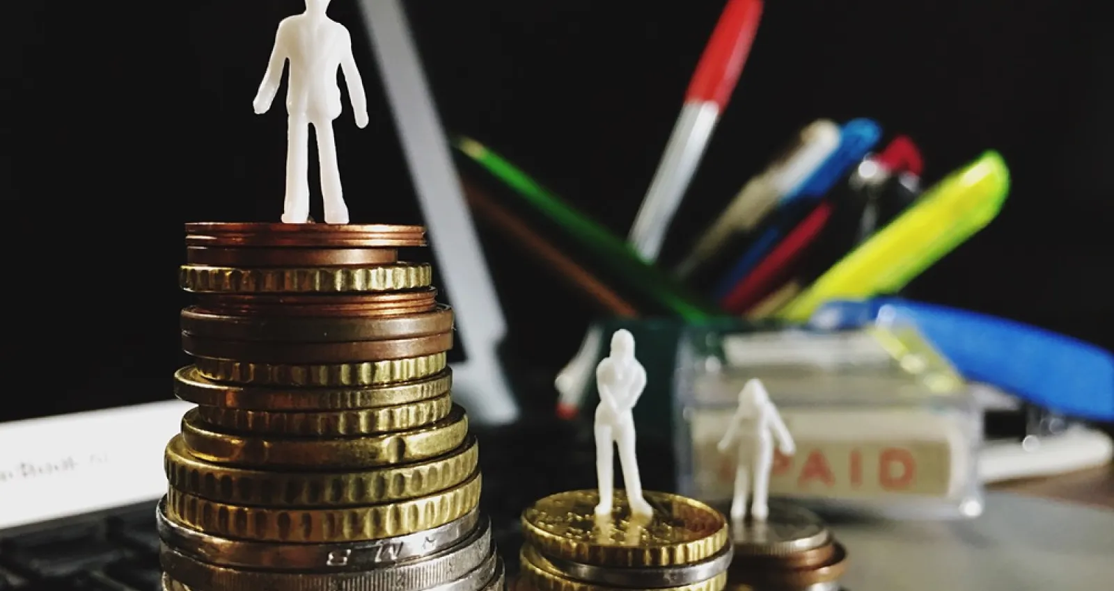 Foto de unas personas sobre monedas de oro en un escritorio