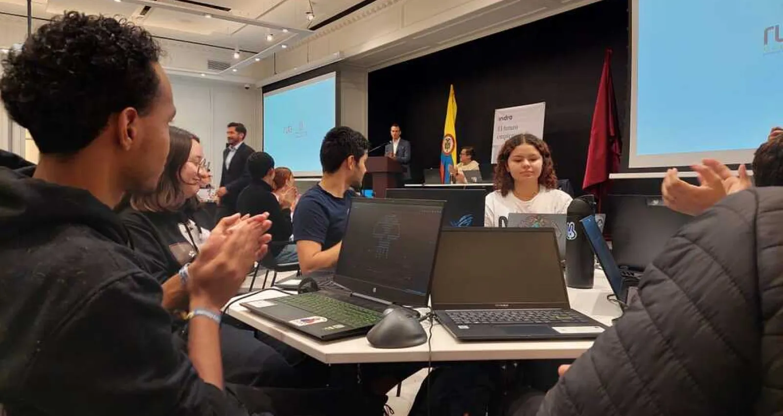 Foto de varias jóvenes sentados en una mesa mirando el computador