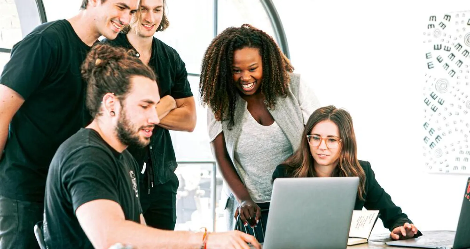 Foto de varias personas reunidas frente a un computador