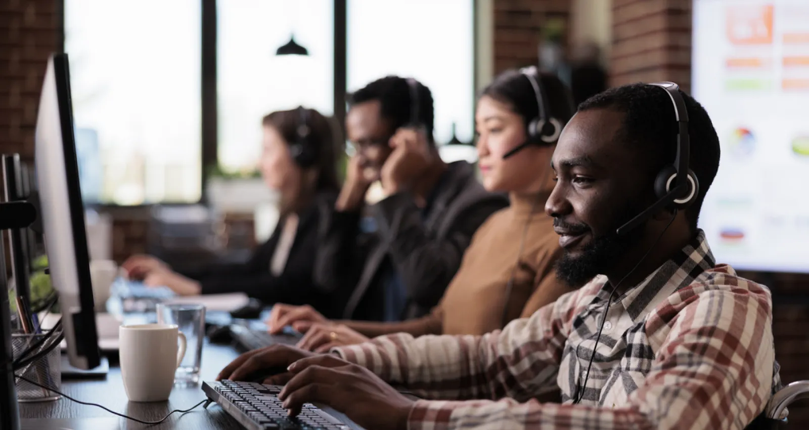 Foto de varias personas trabajando en una emrpesa frente al computador