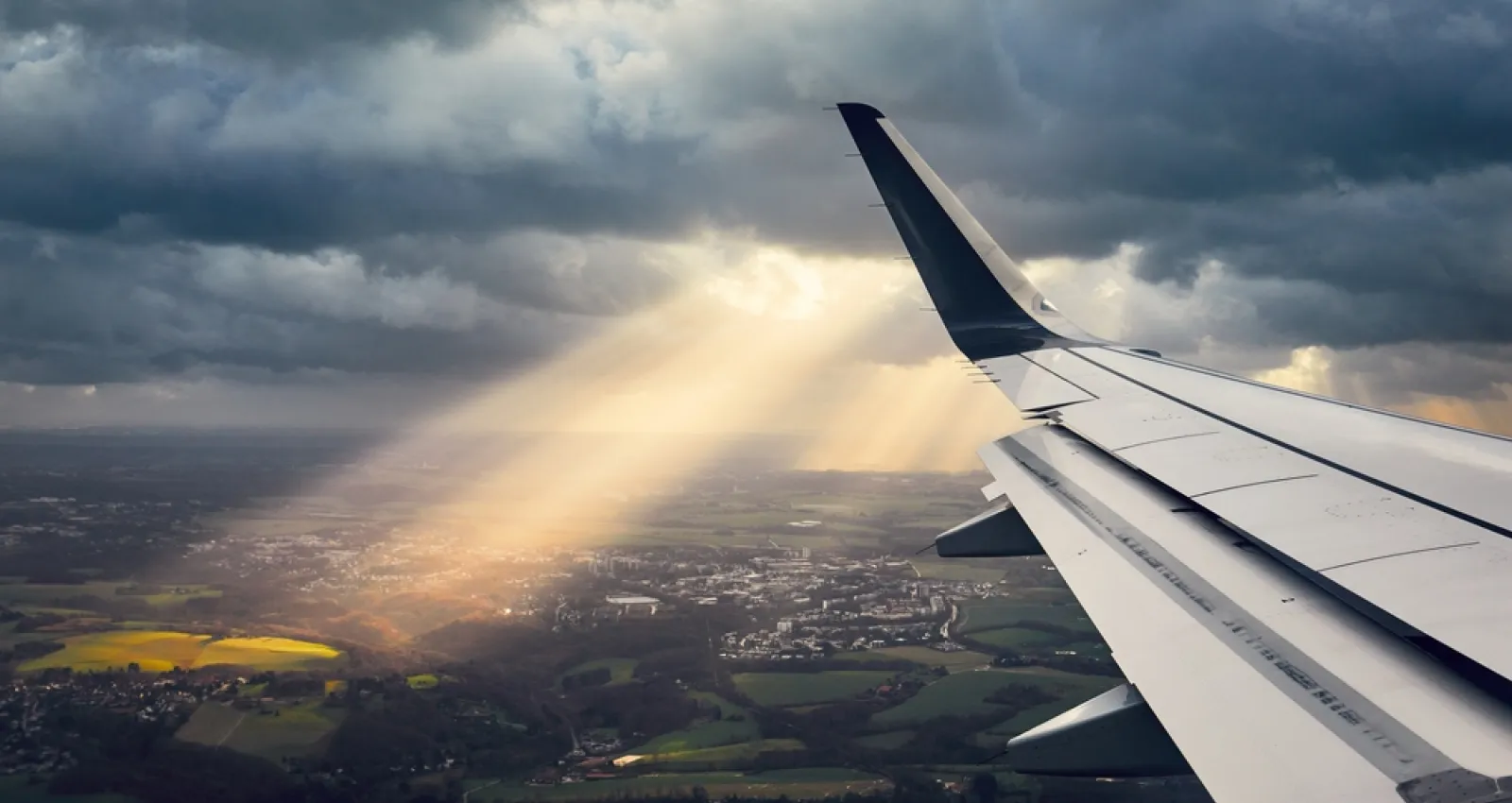 Foto del ala de un avión con un fondo terrestre