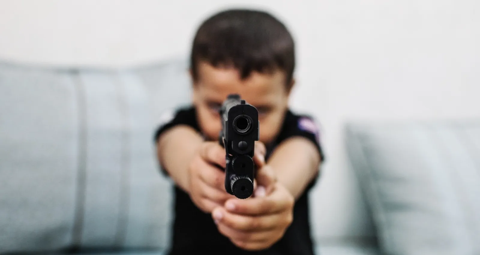 Foto ilustrativa de un niño con un arma