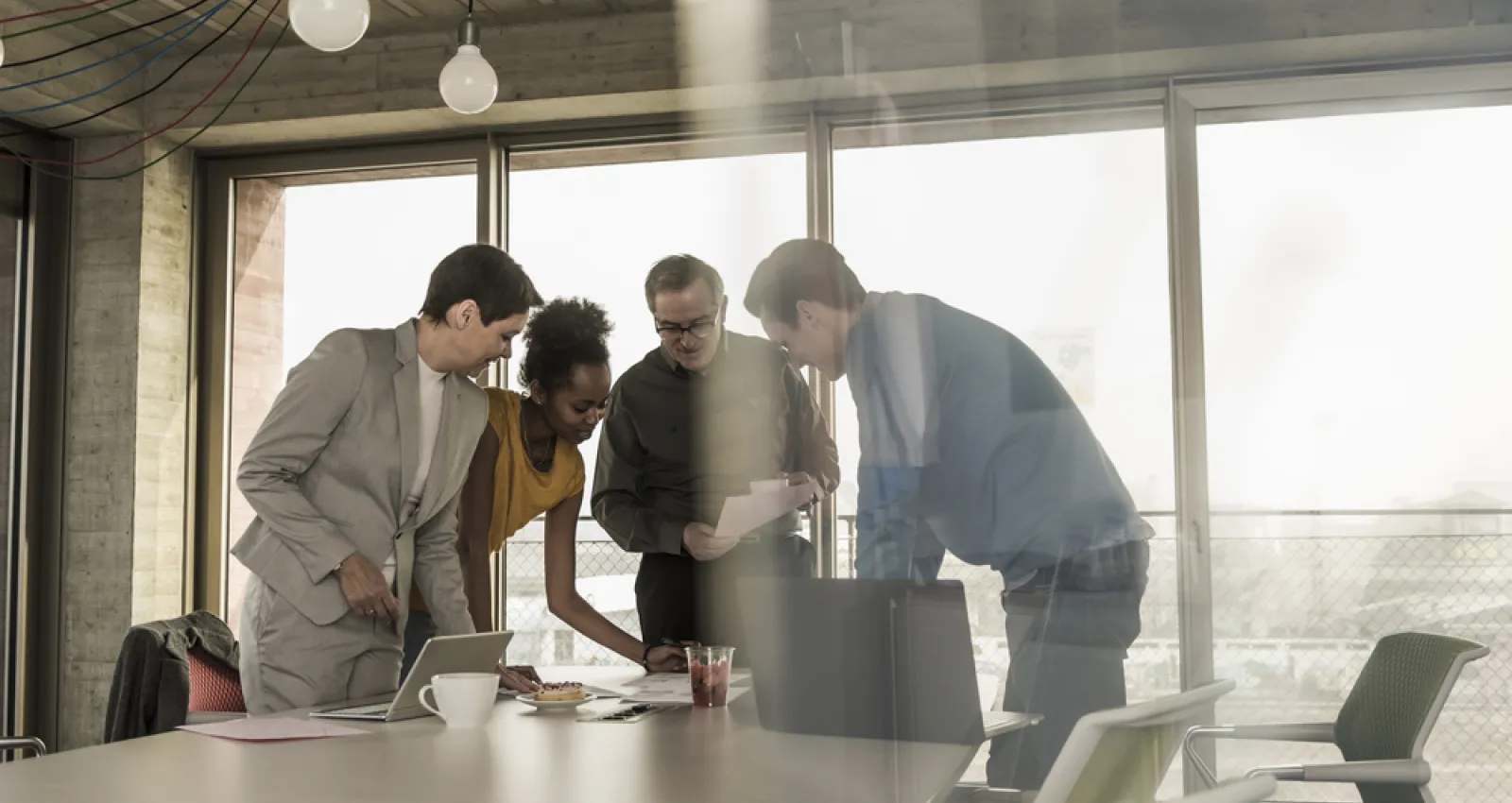 Fotografia de un equipo de trabajo hablando sobre una mesa