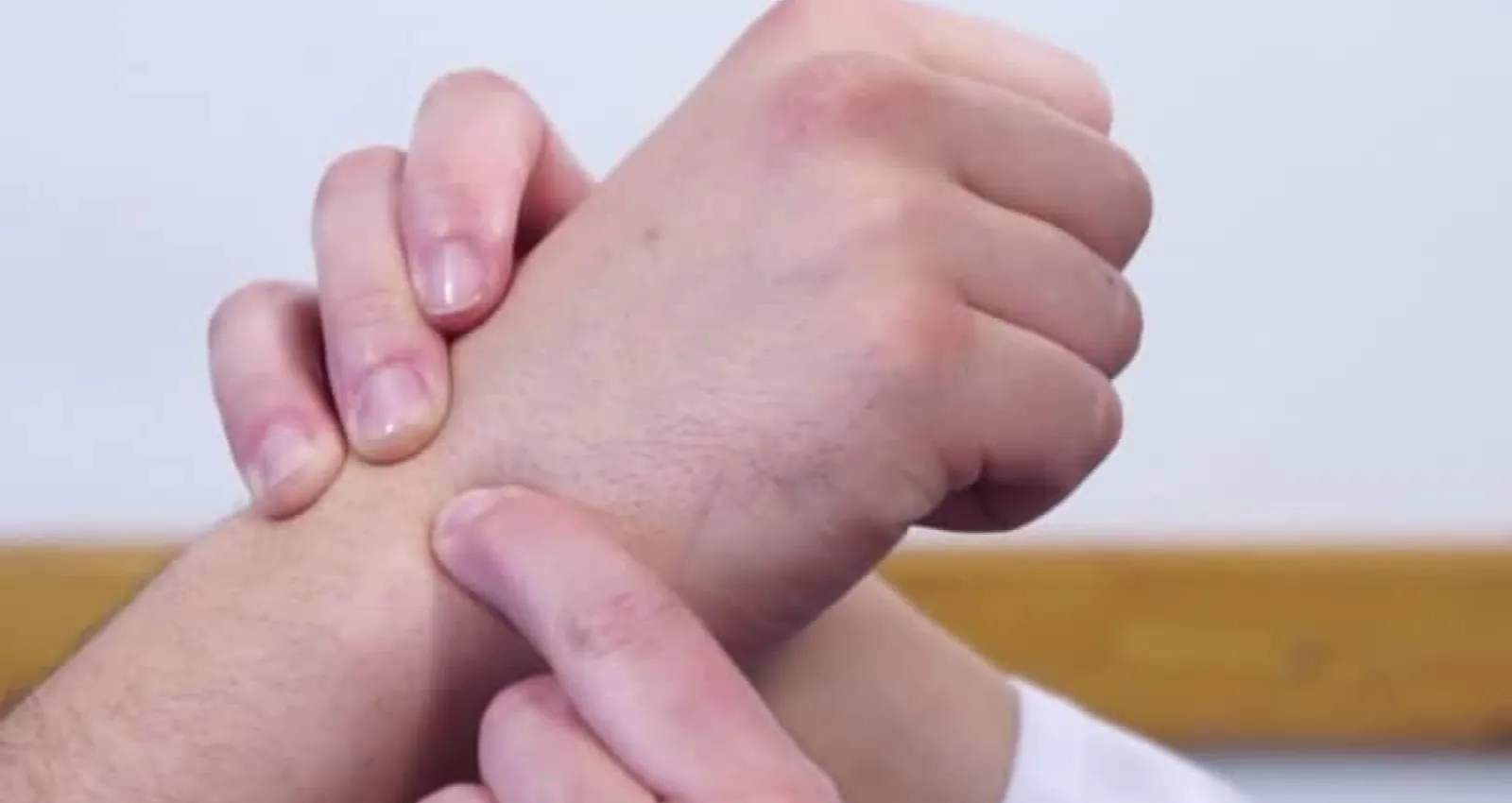 Fotos de una persona señalando la muñeca en la mano de un tercero