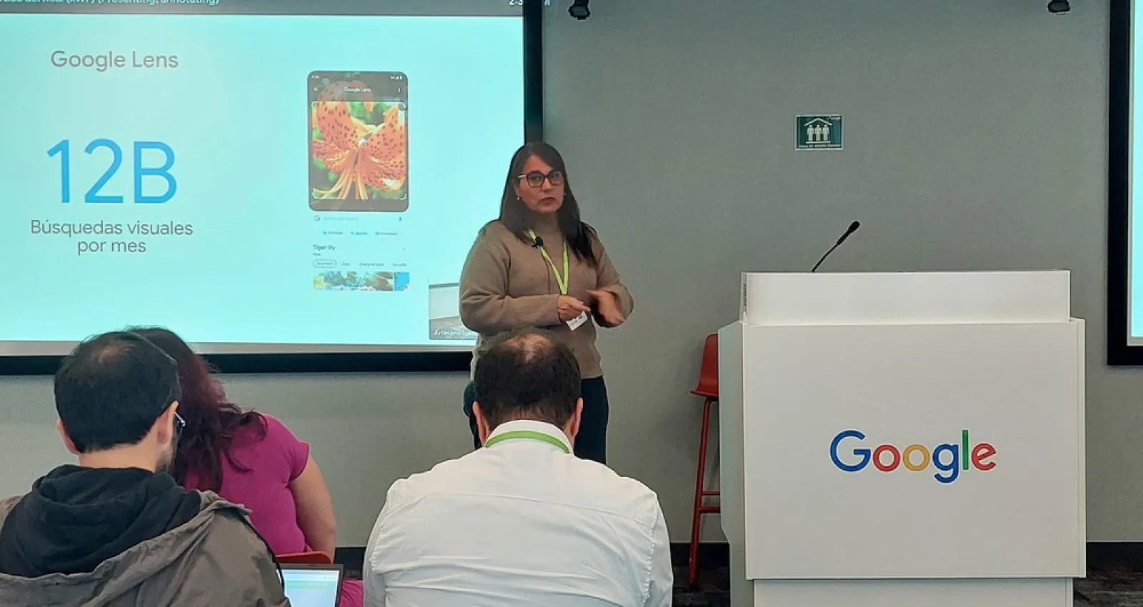 Foto de una mujer exponiendo frente a un escenario de Google