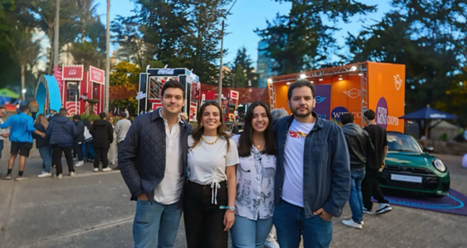 Foto de cuatro personas con un fondo de festival