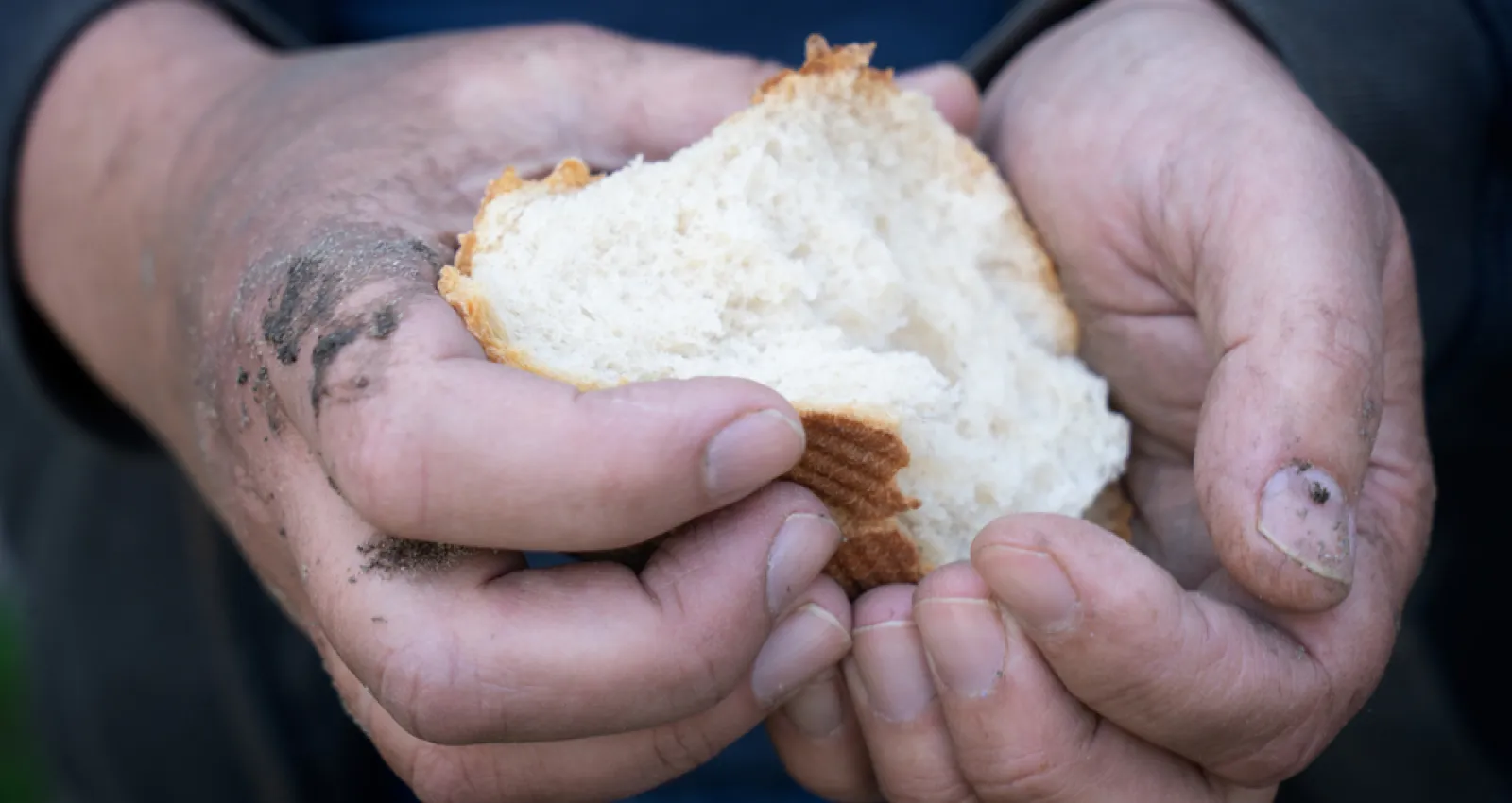 Imagen de una persona con un pan en la mano.