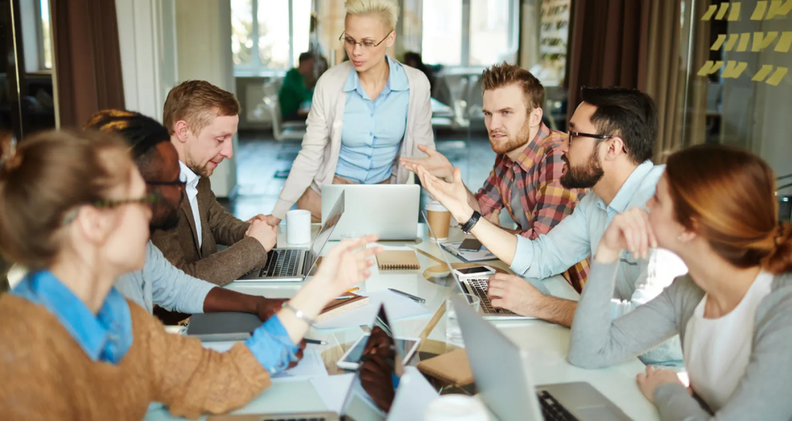 Hombres y mujeres en una mesa compartiendo ideas