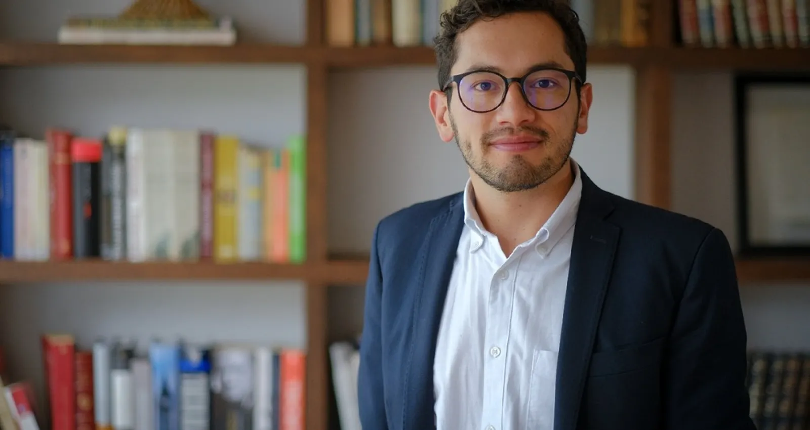 Foto de un hombre con camisa blanca y traje azul mirando a la cámara