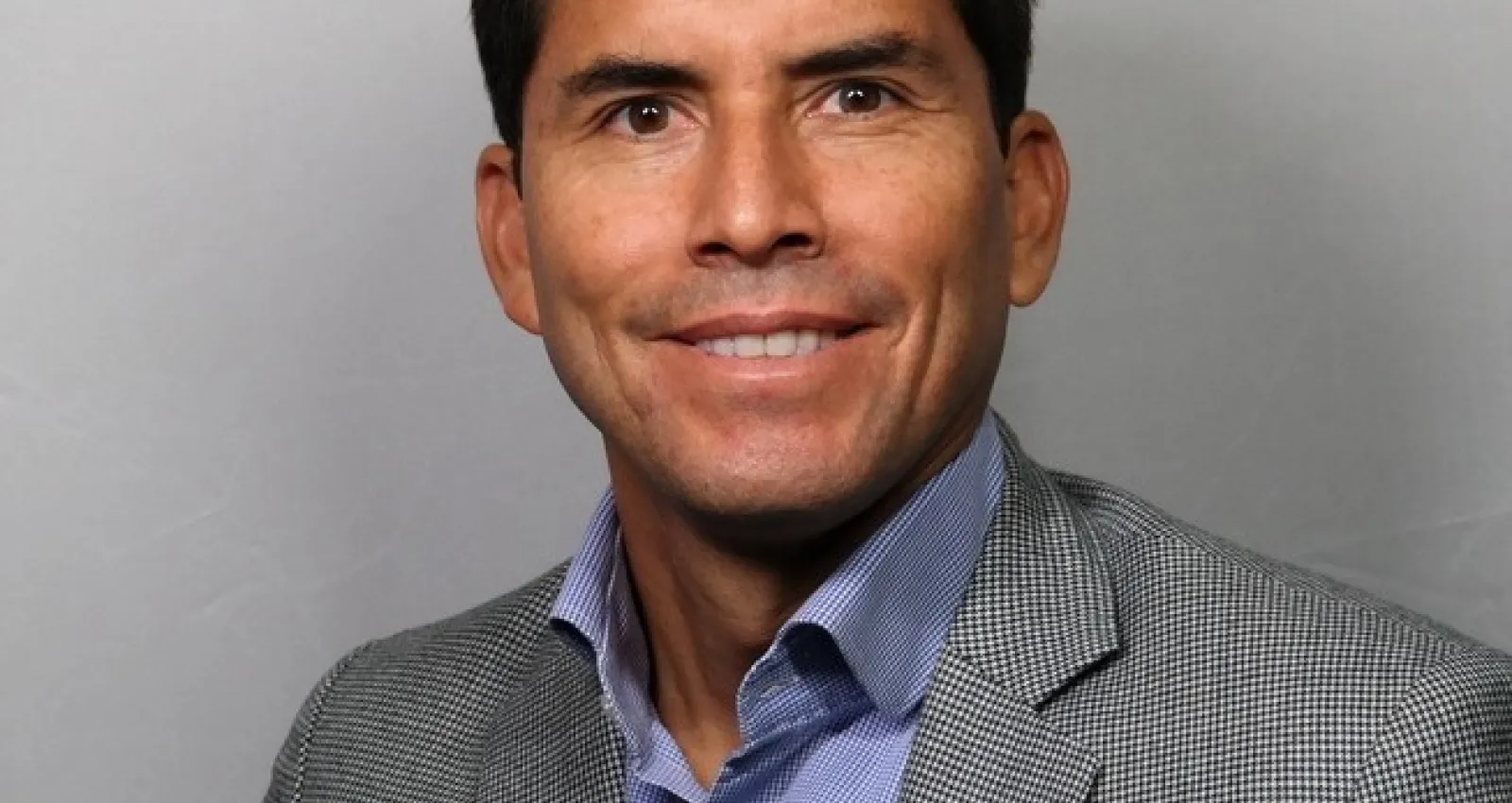 Foto de un hombre sonriendo a la cámara