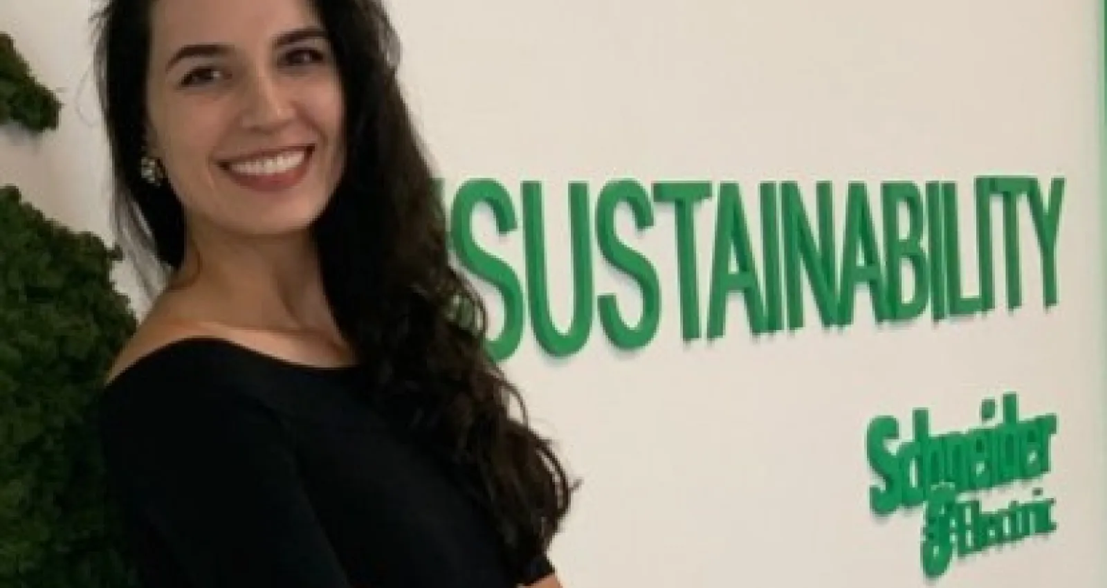 Foto de una mujer posando al frente de un logo de Schneider