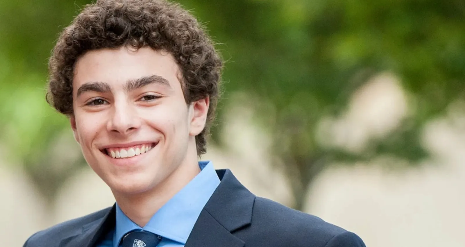 Foto de un jóven sonriendo a la cámara