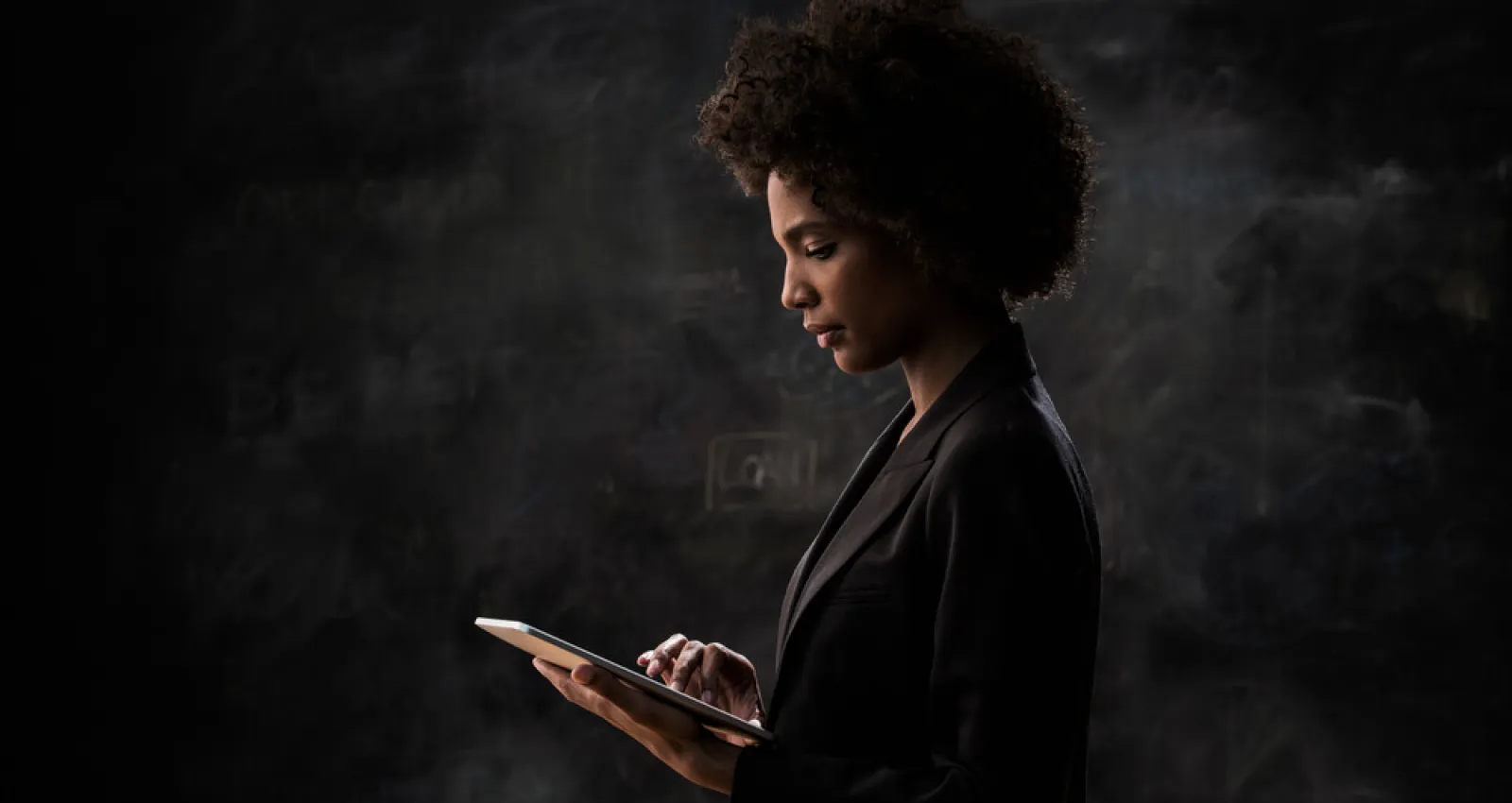 Mujer mirando computador con fondo negro