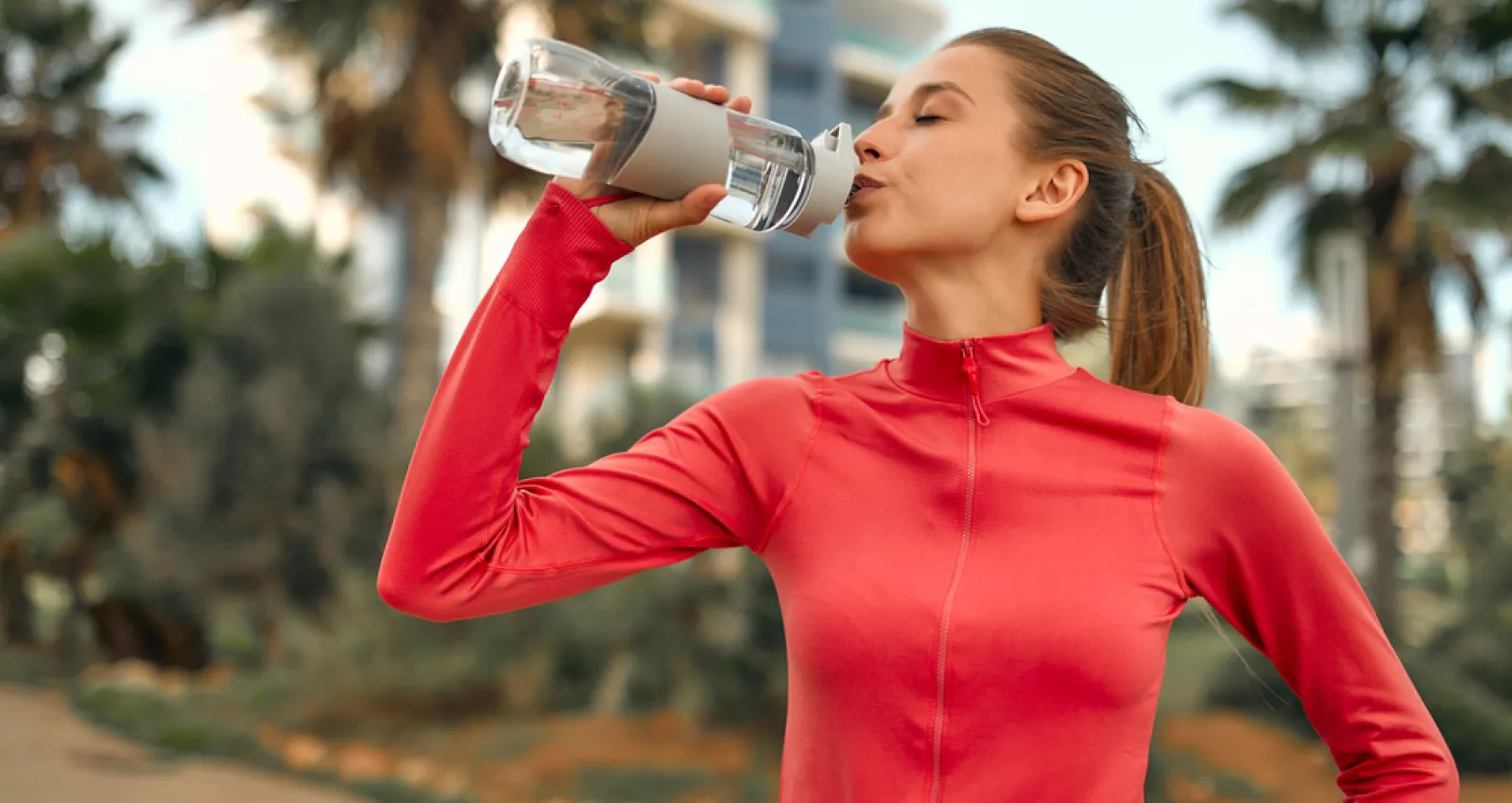 Mujer tomando agua de un termo