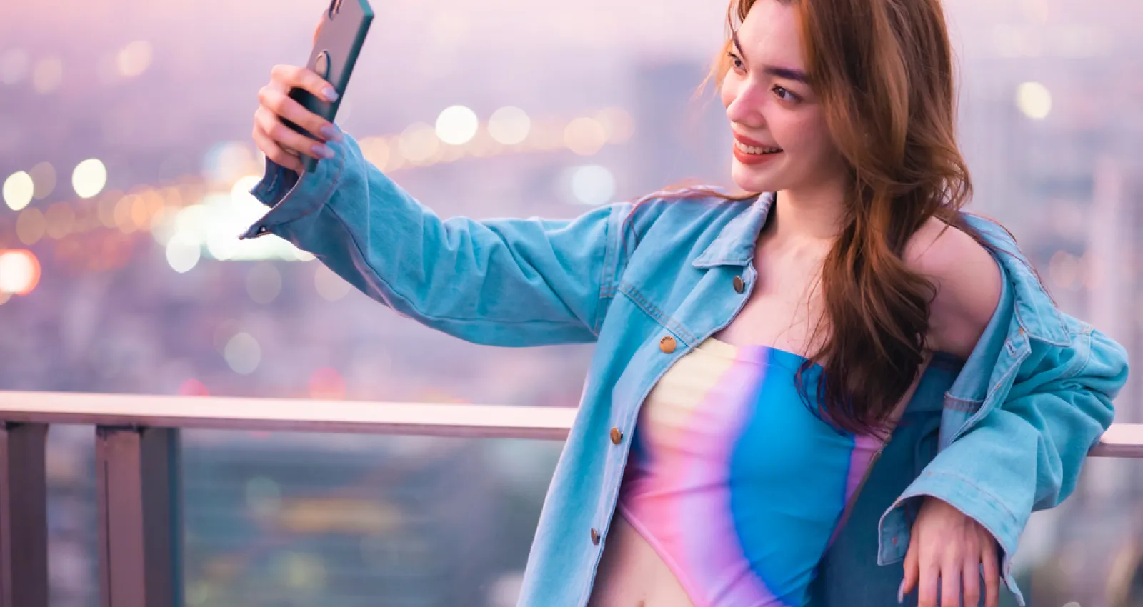 Mujer tomándose una fotografía con un fondo de ciudad