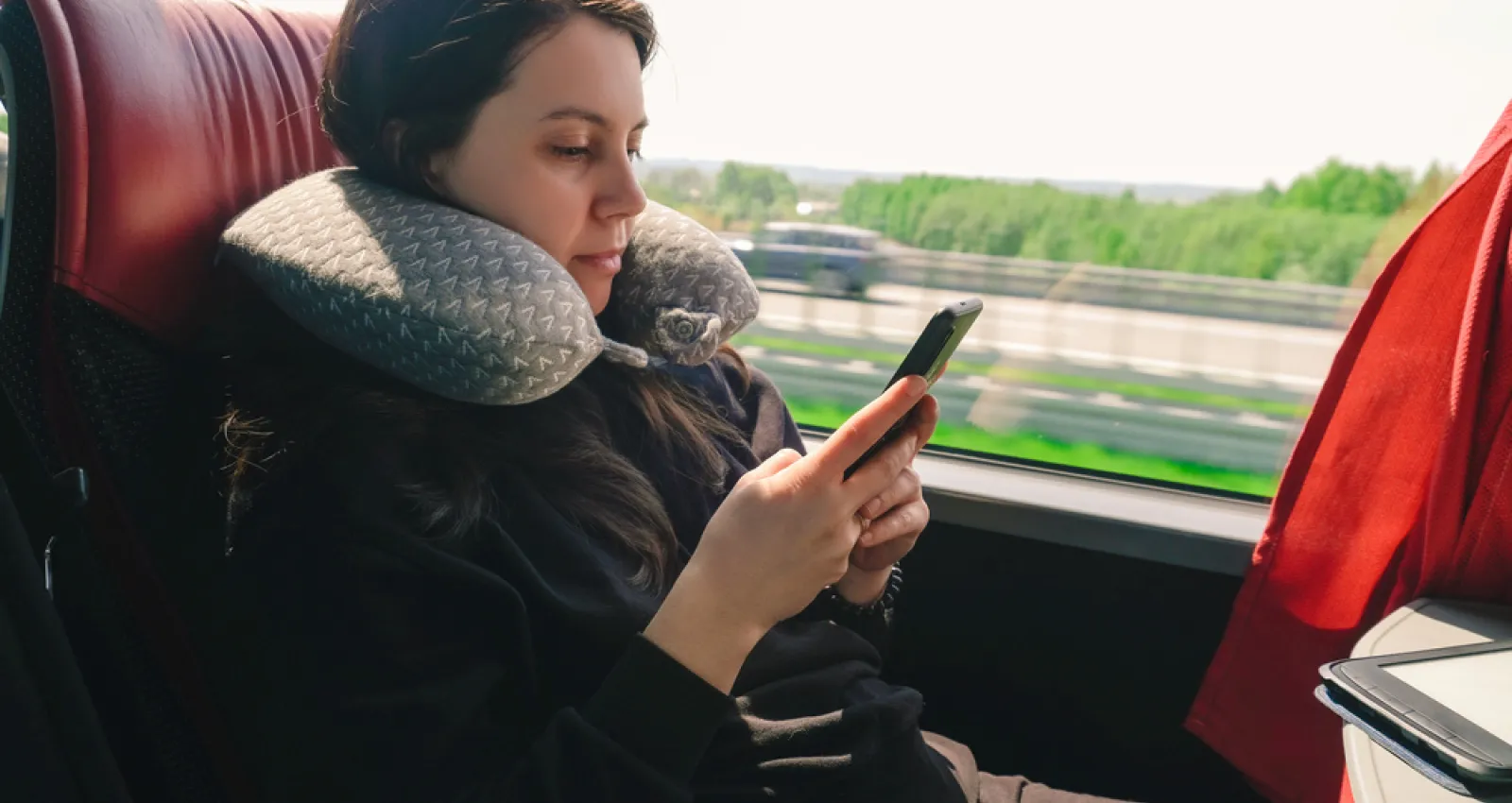 Una mujer viaja en una flota mientras revisa su celular