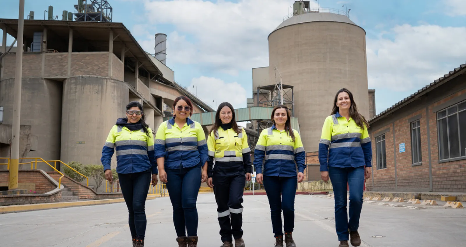 Mujeres Holcim con un fondo de fábrica