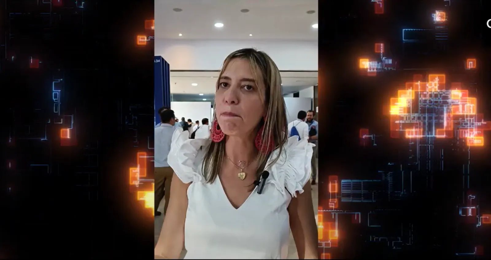 Fotografía de una mujer mona con blusa blanca hablando a la cámara