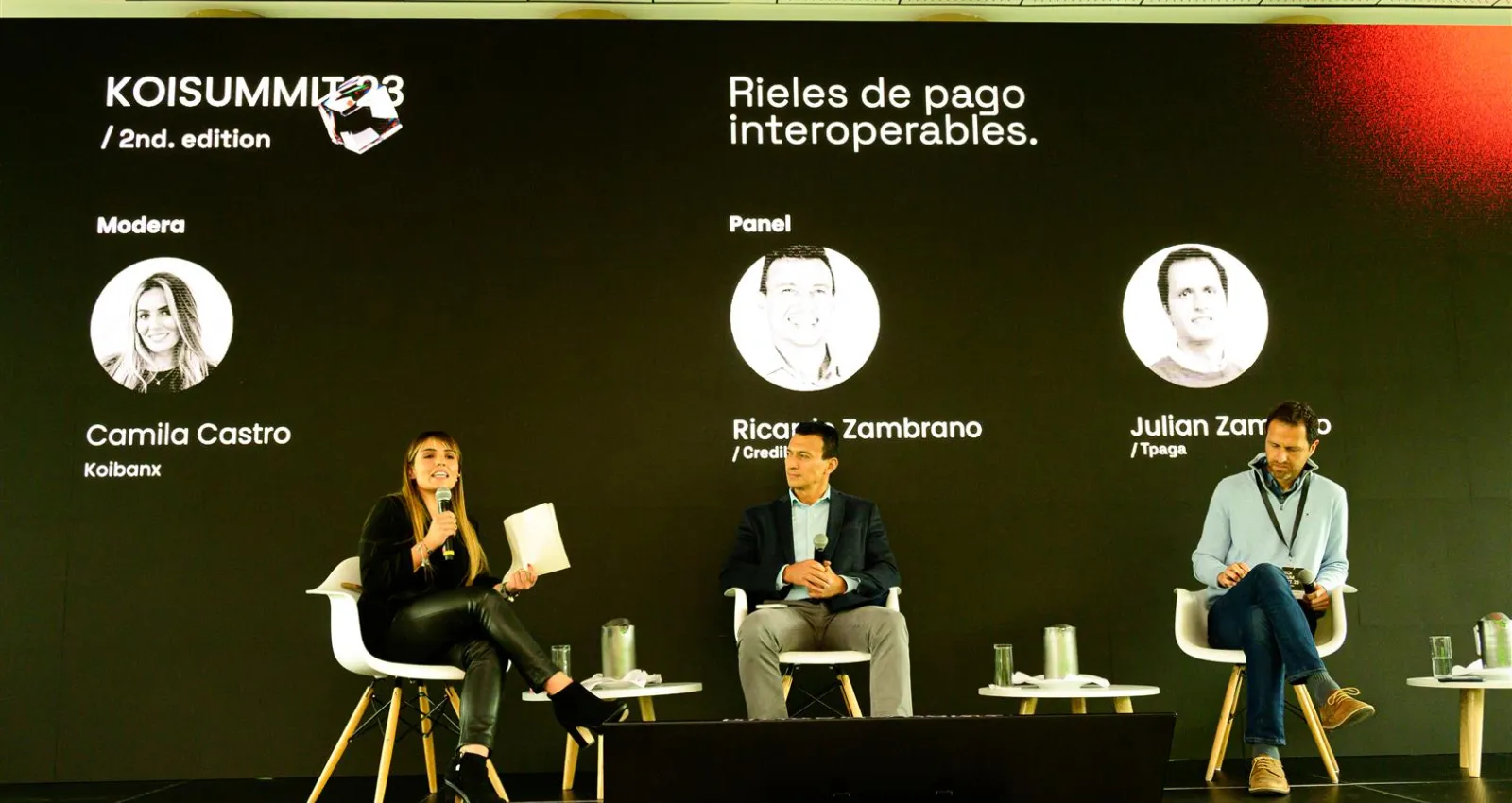 Tres personas hablando sobre una tarima