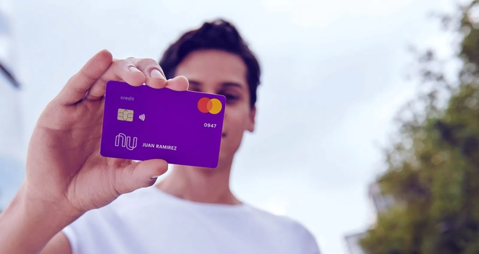 Foto de una persona joven con una carta de crédito en la mano