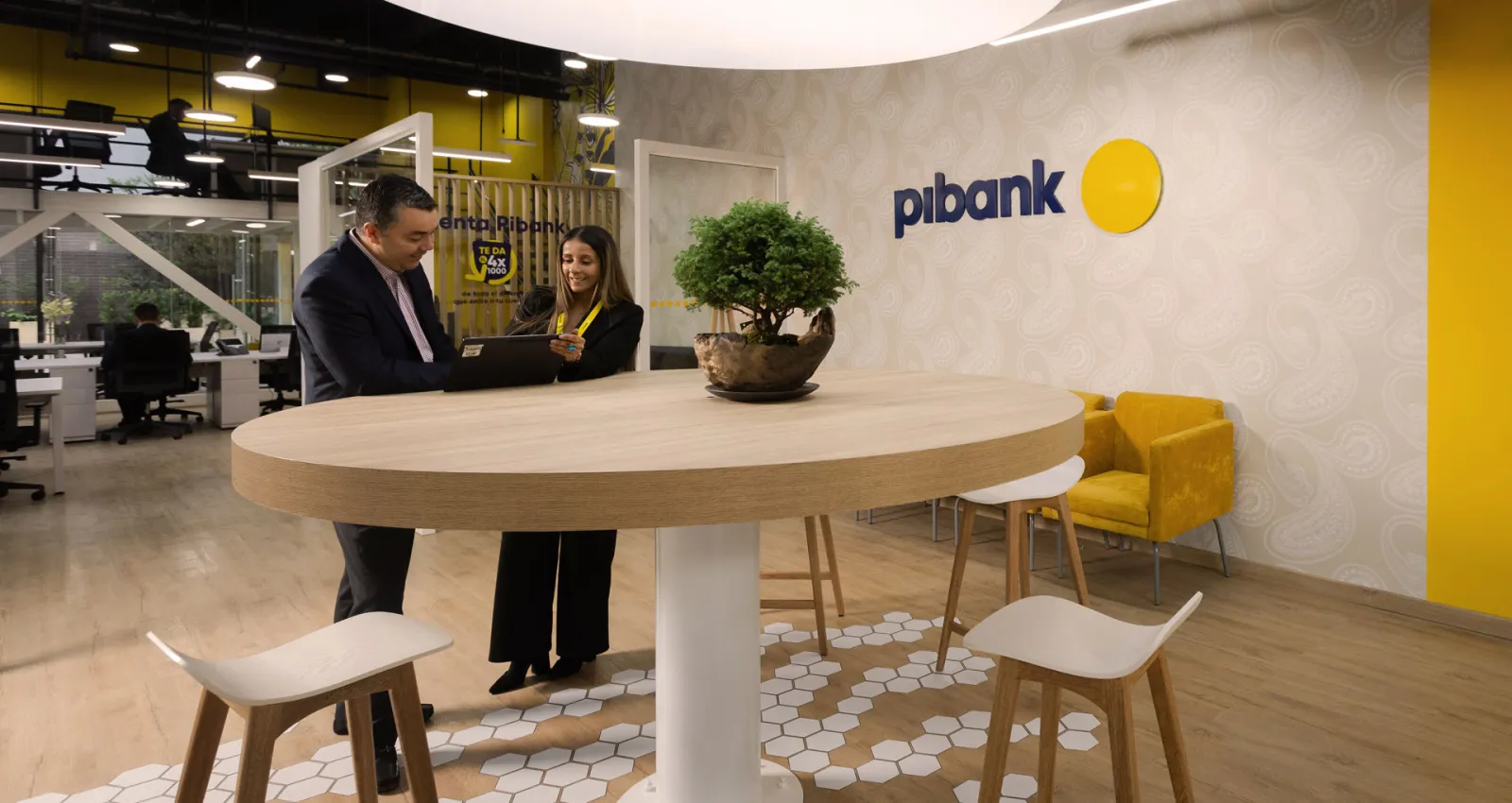 dos personas hablando en una oficina de Pibank
