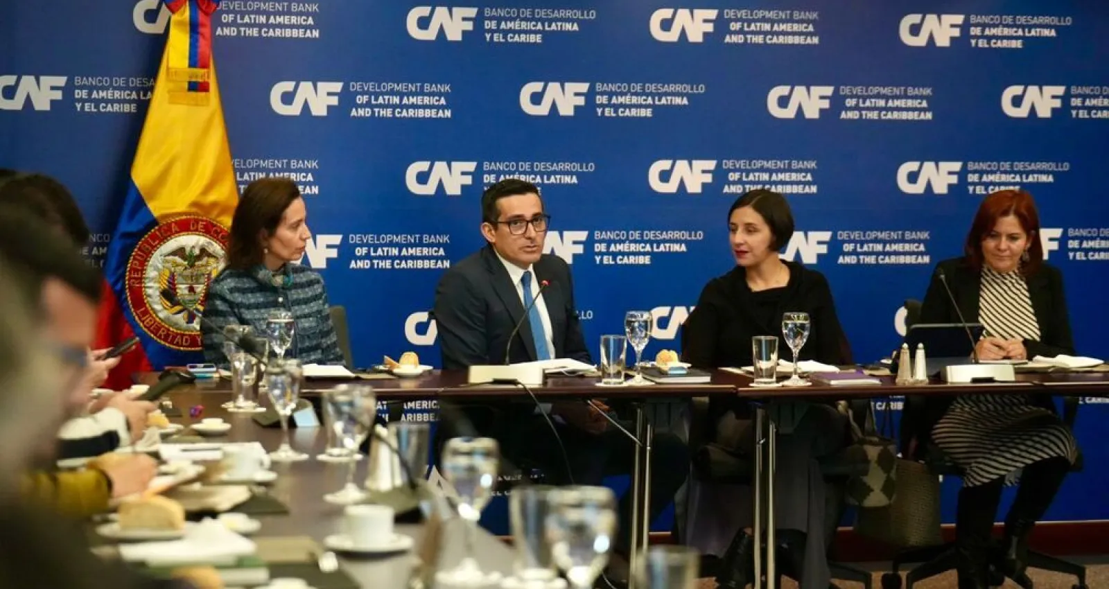 Reunión de cuatro personas sentadas en una mesa conversando