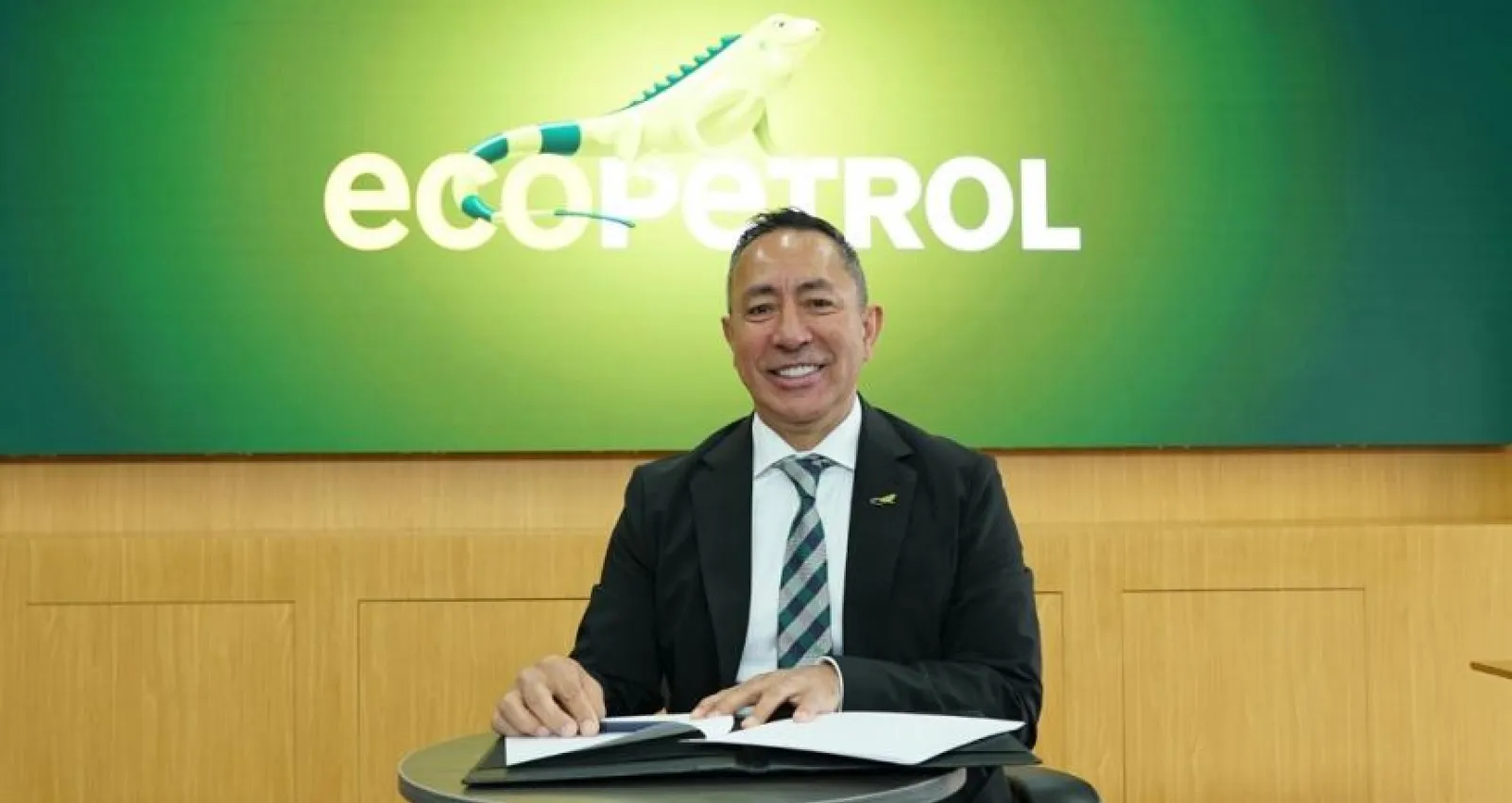 Señor con traje sonriendo a la cámara con fondo verde