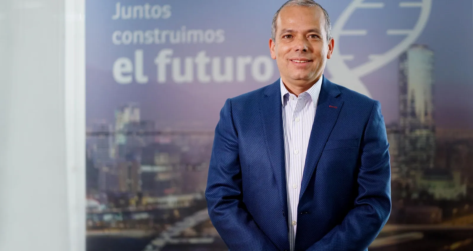 Hombre blanco con camiseta y blazer azul mirando a la cámara bla