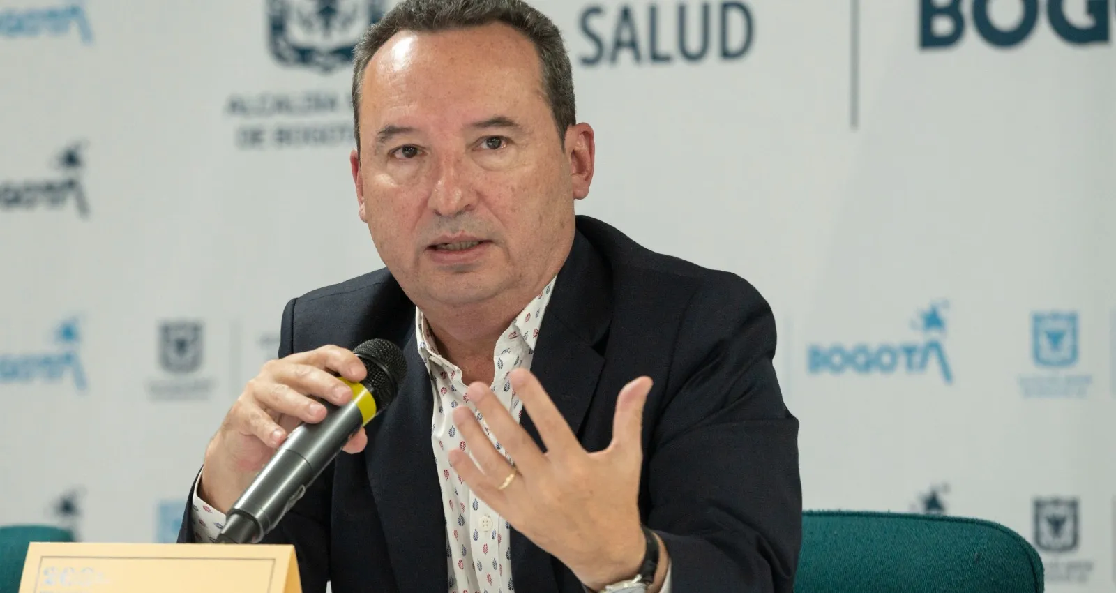 Persona hablando al frente de un micrófono