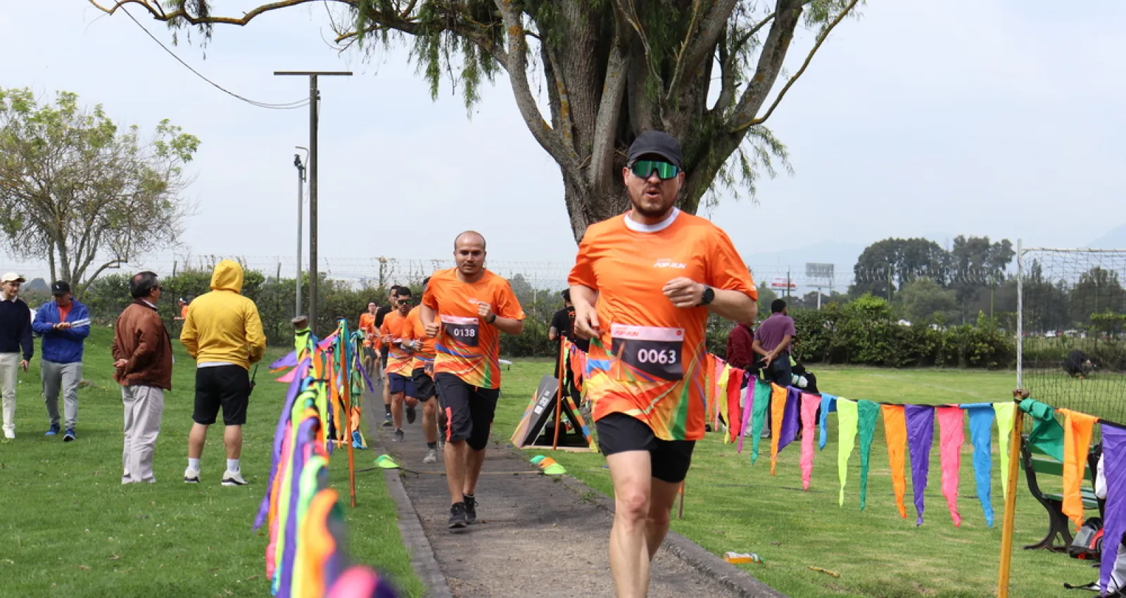 Foto de una persona corriendo en una maratón con una camiseta naranja