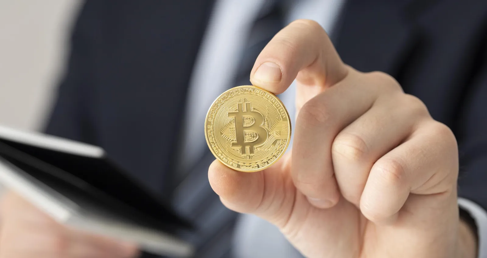 Foto de una personas sosteniendo una moneda con el logo de las cripto