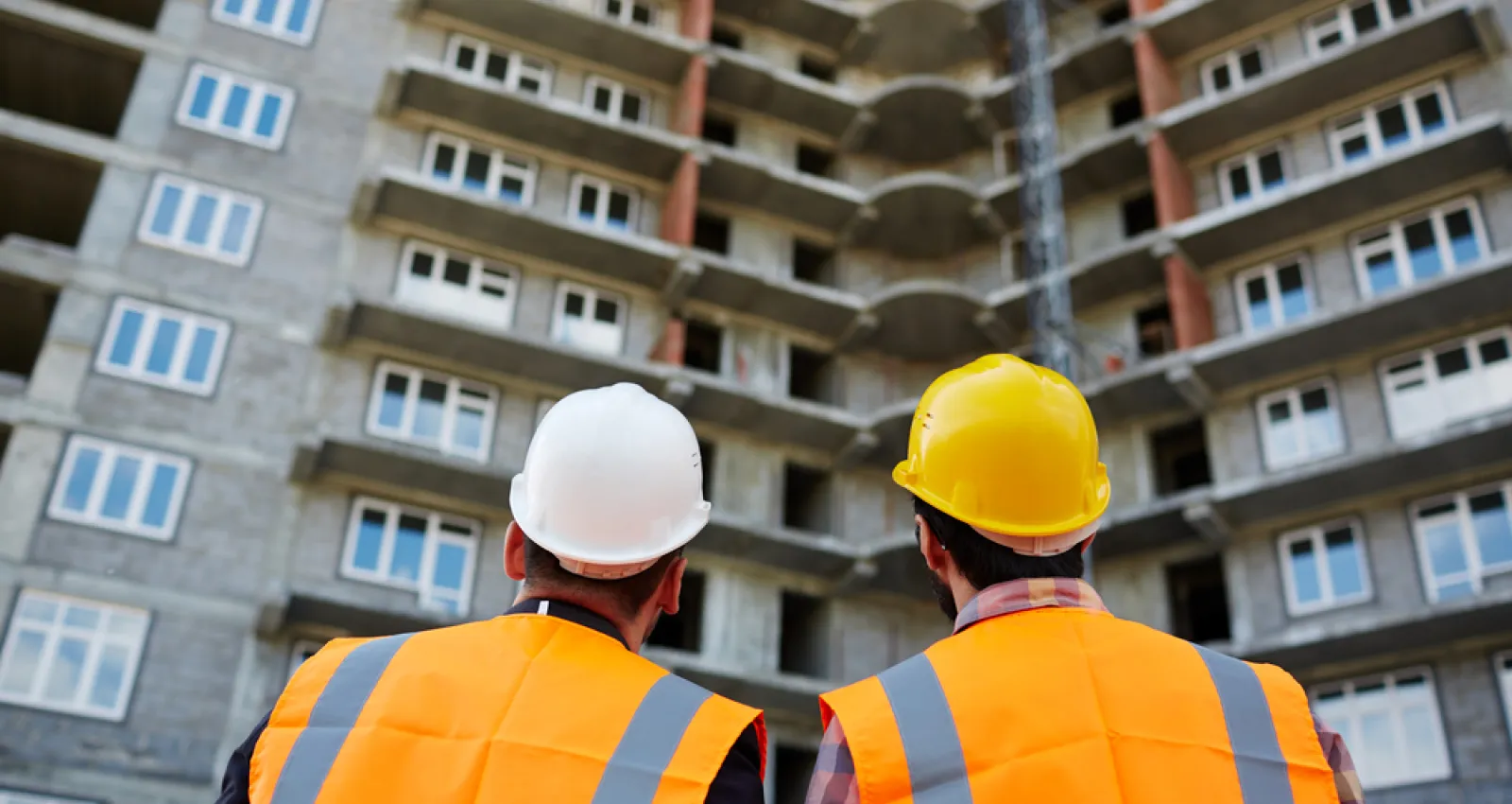 foto de dos arquitectos de espalda mirando  un edificio en construcción